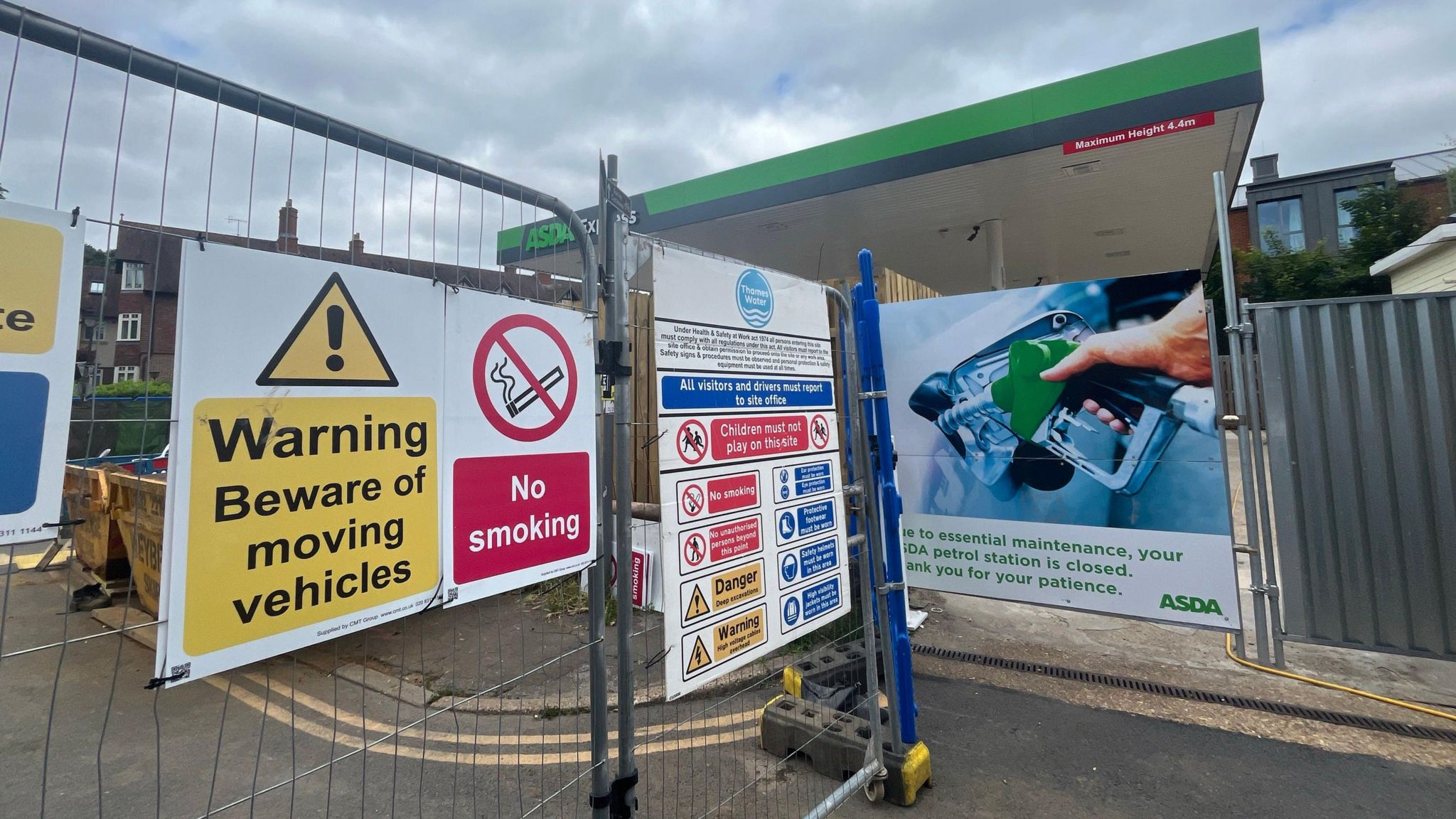 Signs outside a petrol station on fencing