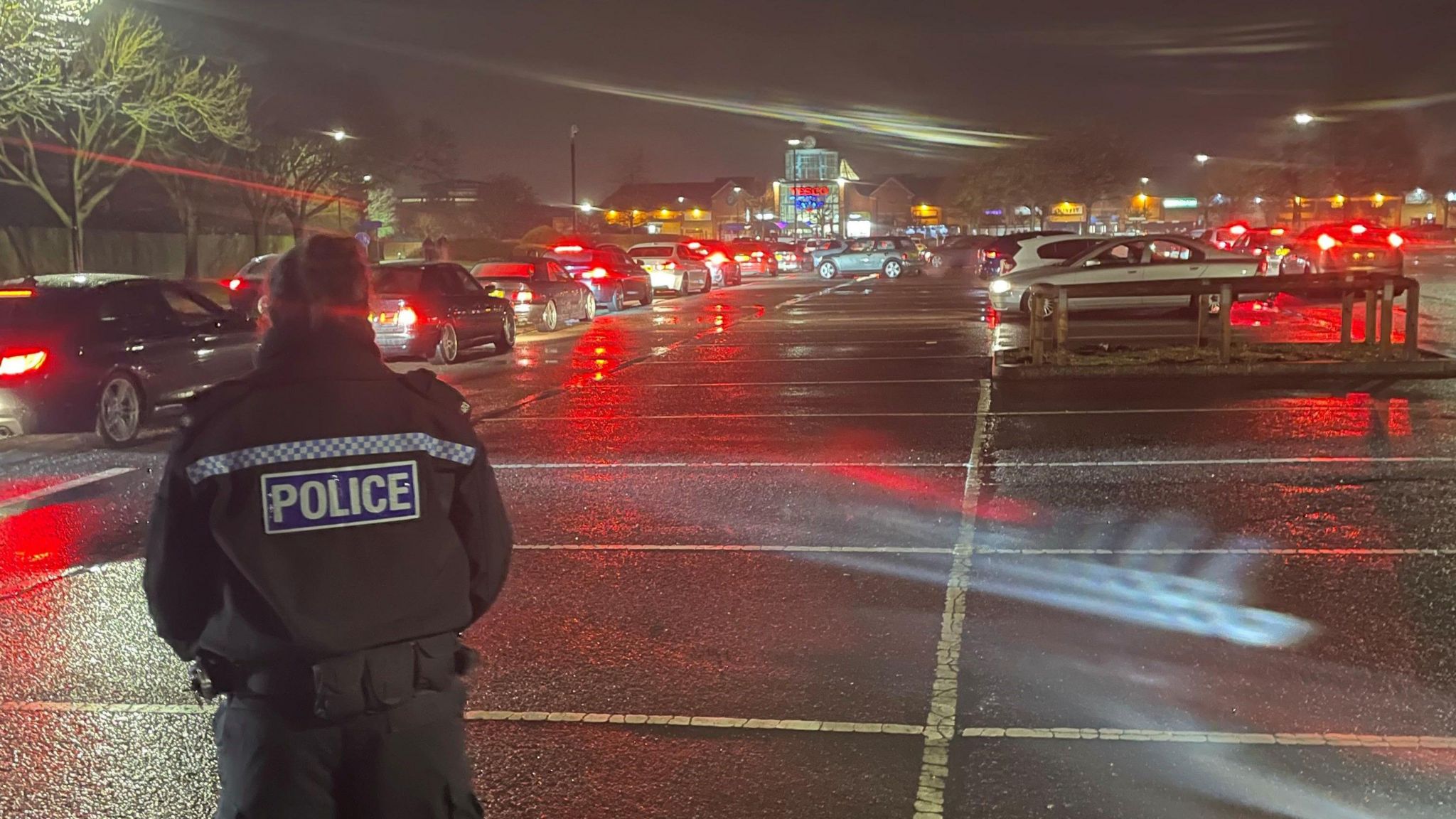 Police officer stood in a car park