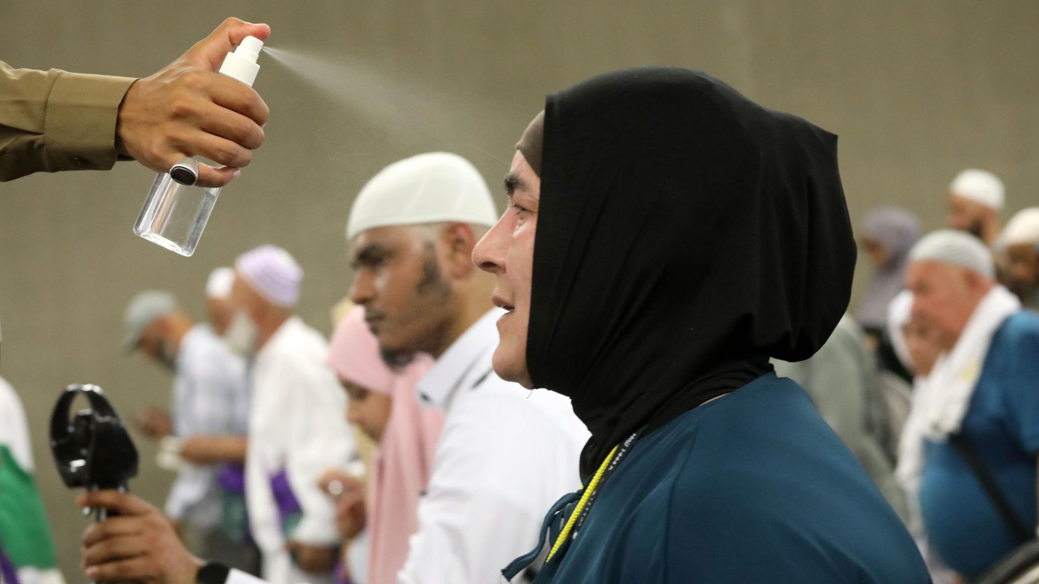 An official sprays water in a woman's face to cool down