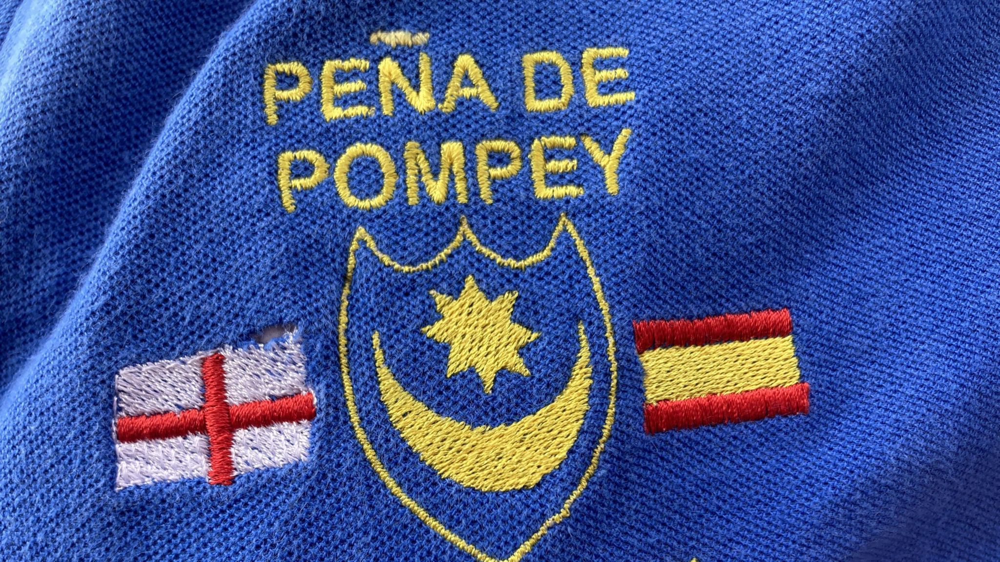 Pompey crest with England and Spain flags