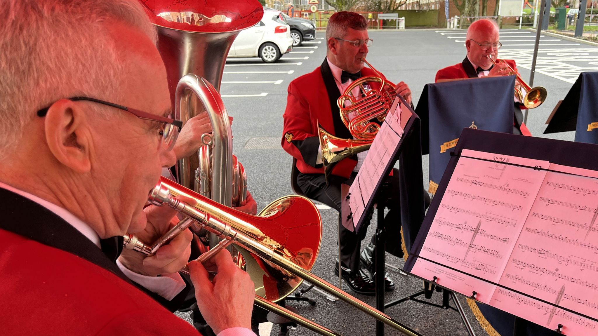 The Ceremonial Military Band playing their brass instruments under a gazebo