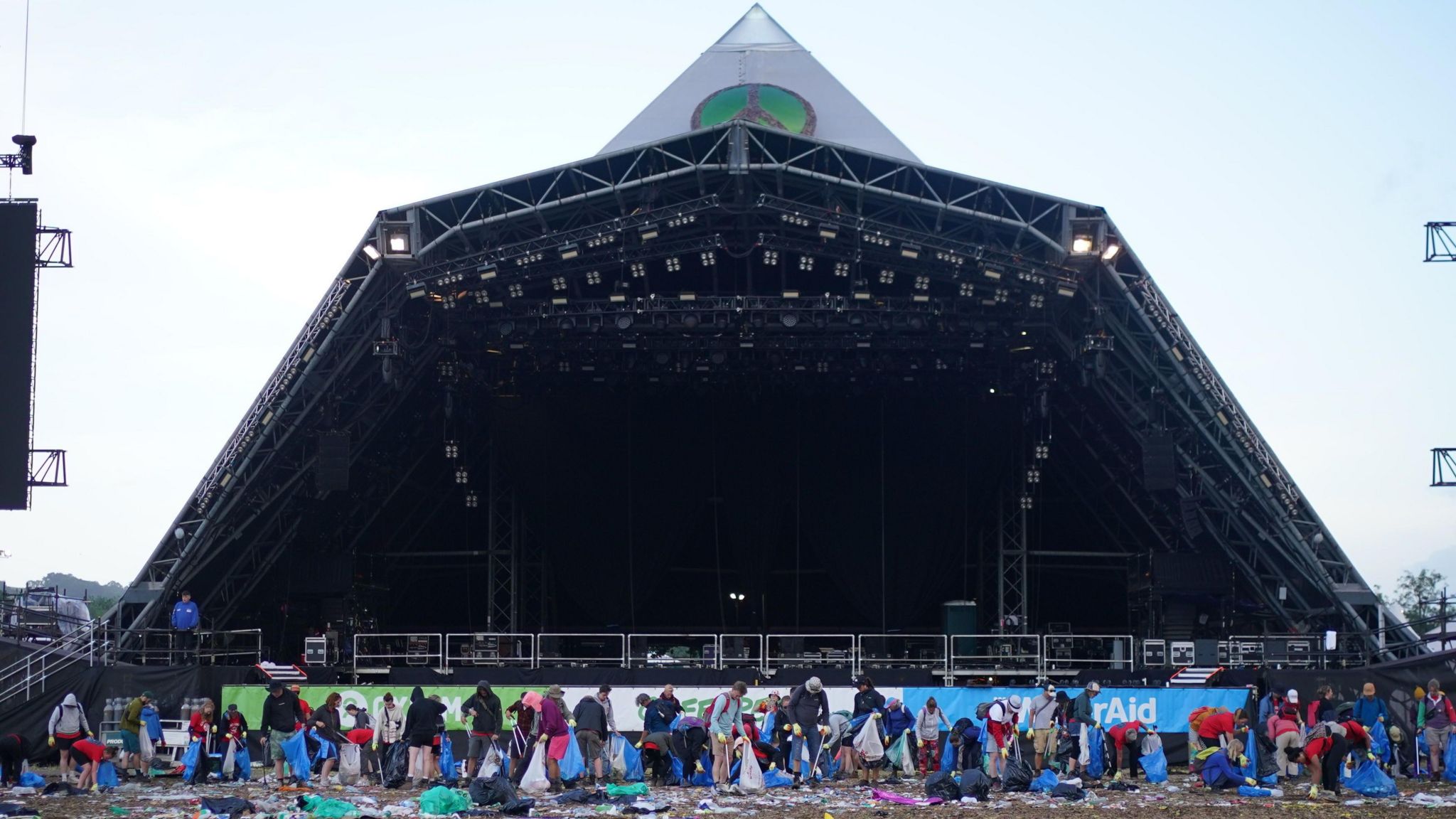 People cleaning up in front of the Pyramid Stage