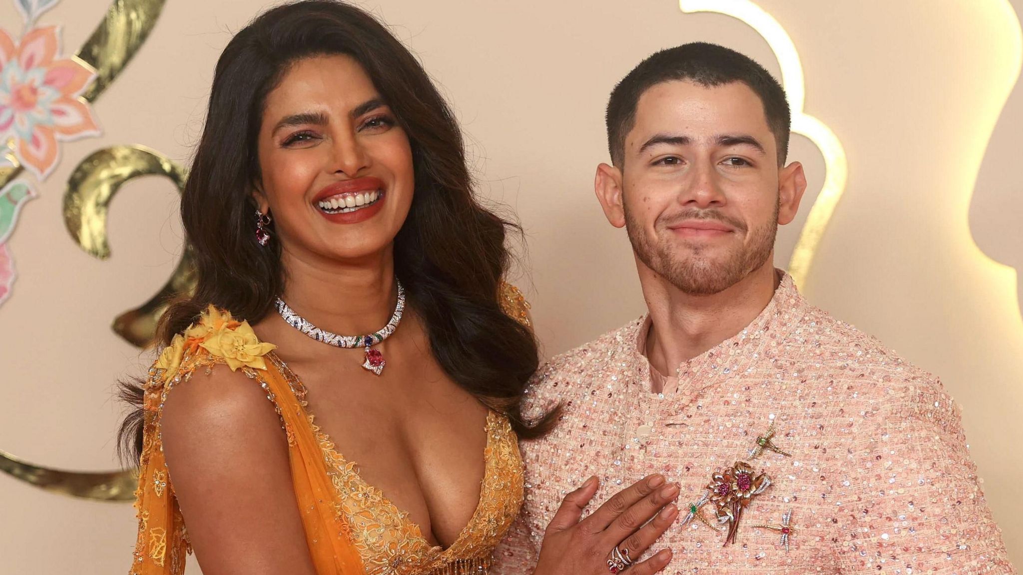 Priyanka Chopra (L) and her husband US singer Nick Jonas pose for photographs.