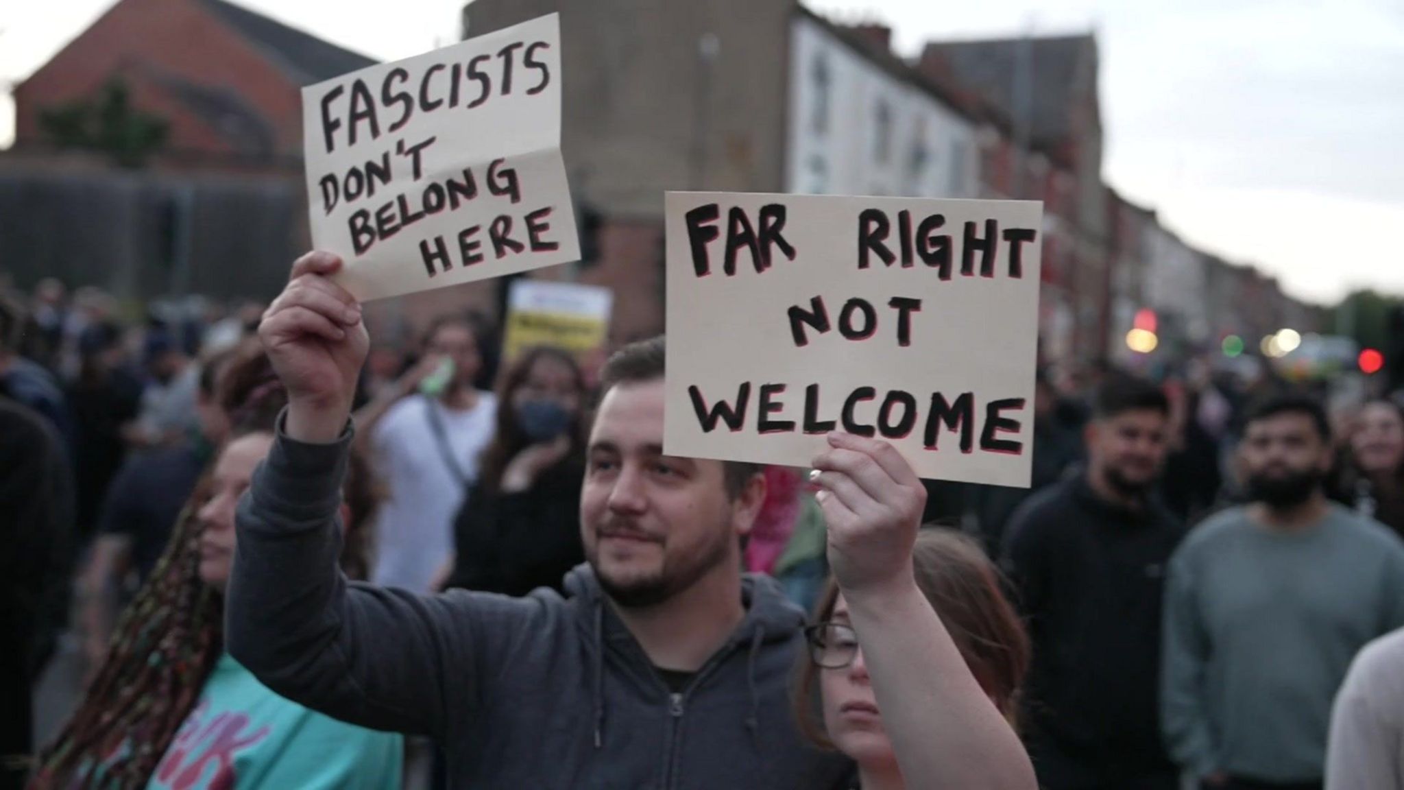 Counter-protesters in Northampton hold signs that read "Fascists don't belong here" and "Far right not welcome"