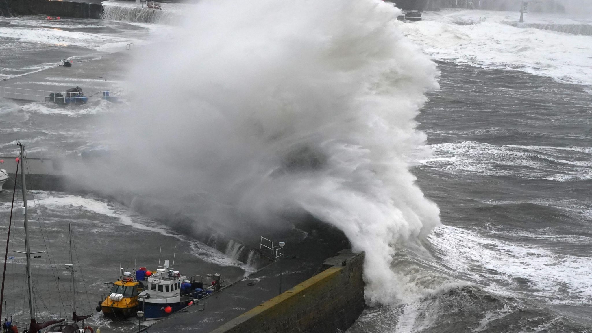 Large waves at Stonehaven harbour with water breaking over the harbour wall