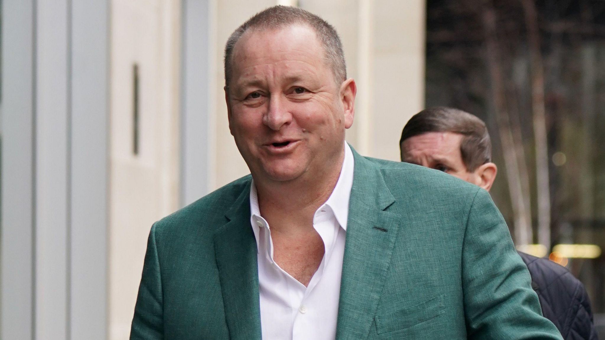Mike Ashley wearing a green jacket 