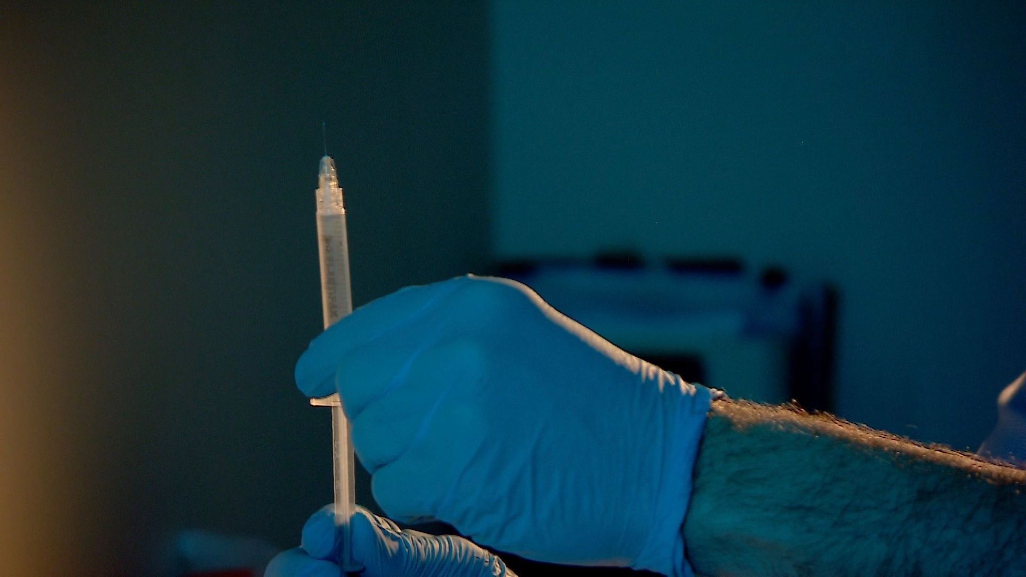 Unidentified doctor pulling syringe of injection