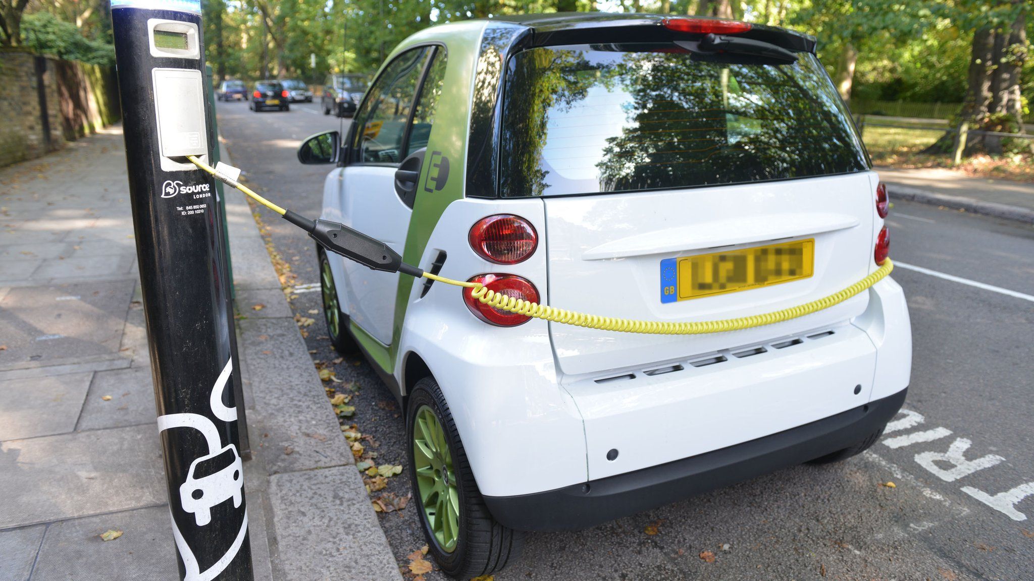 A small electric car (make unknown) recharging at a Source London charge point on South End Road, Hampstead, London