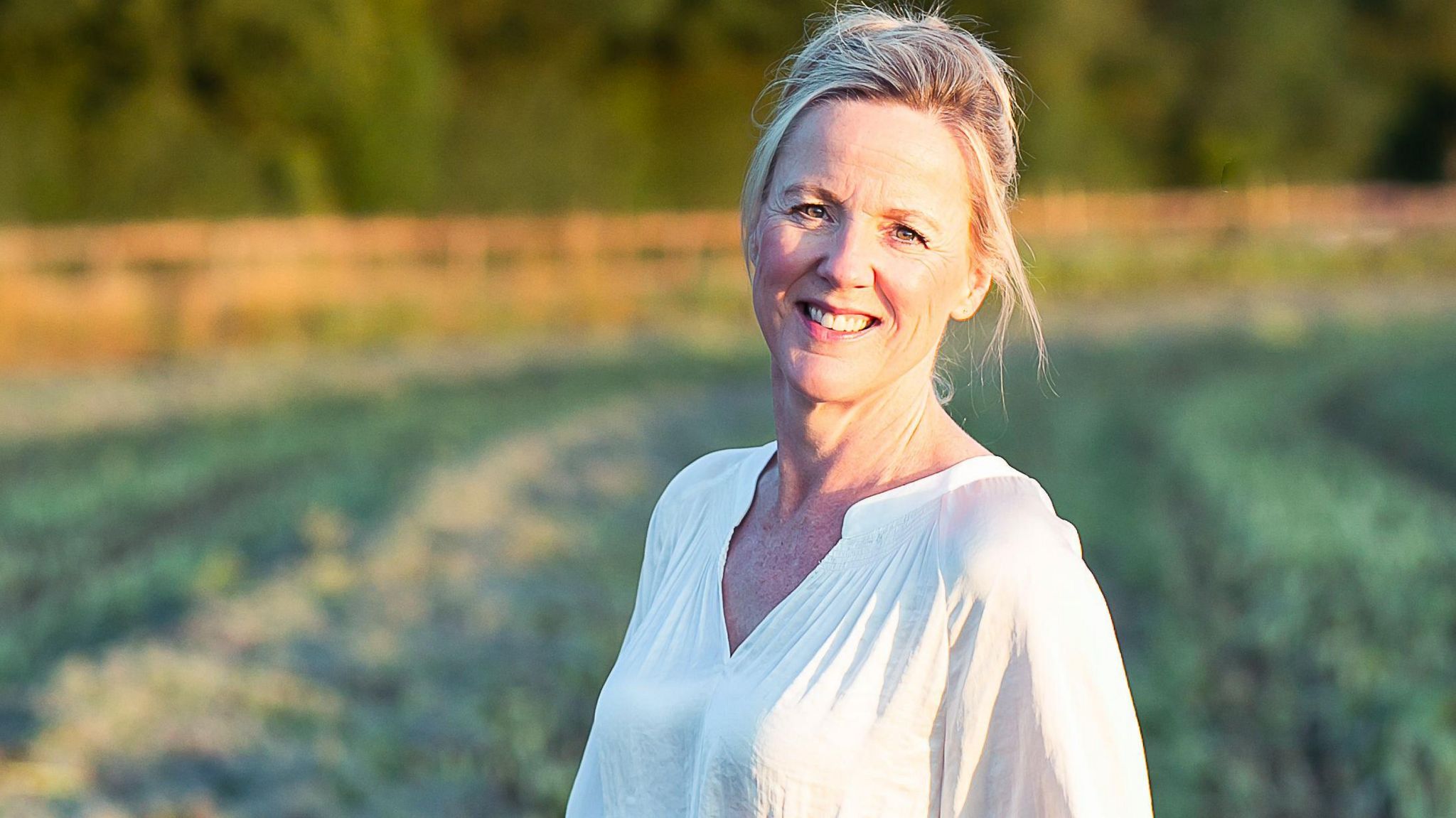 Binnie Grant, who is wearing a white top and standing in a field