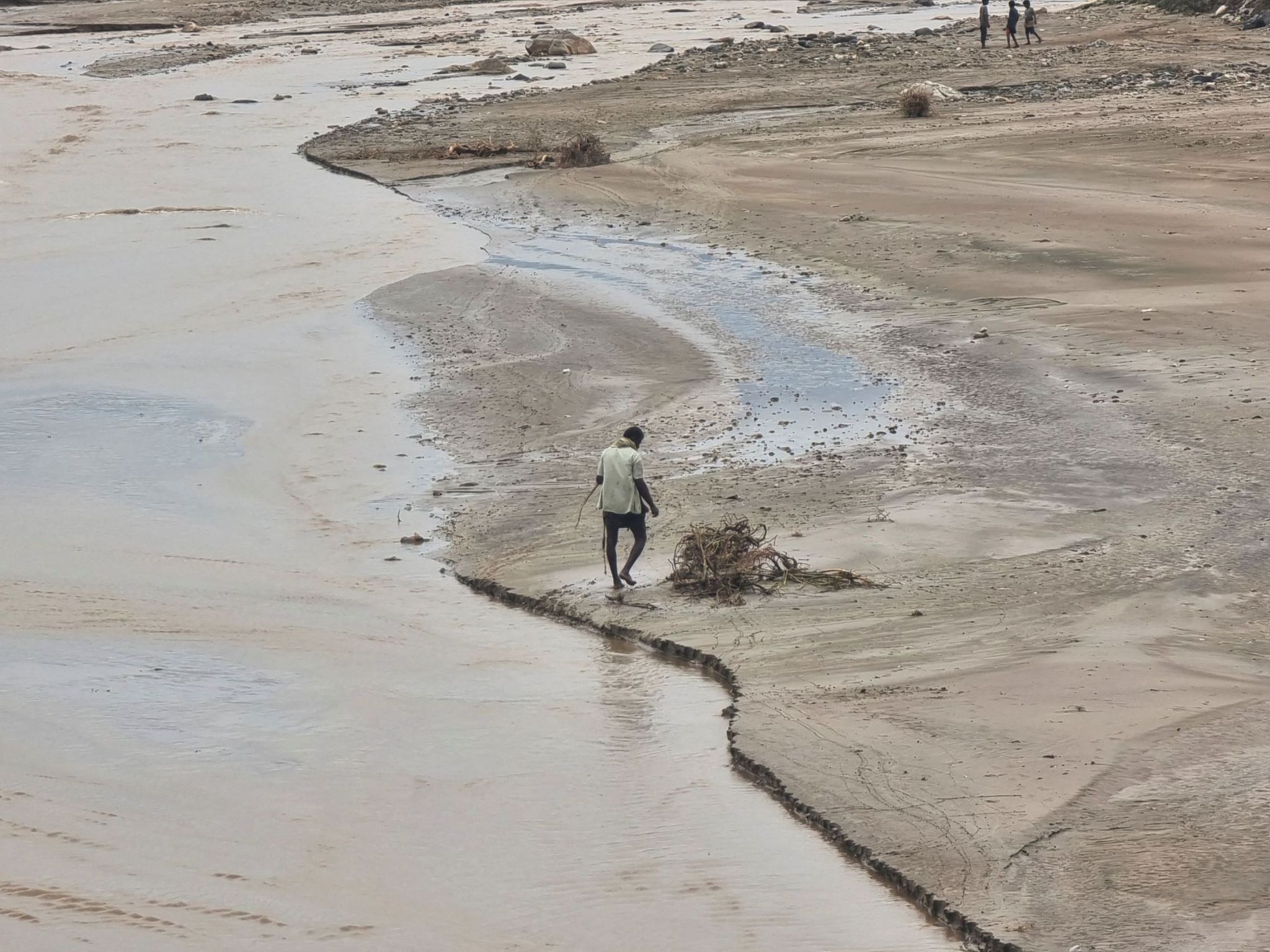 A man walks near flood water following heavy rains in the province of Hajjah, Yemen. 