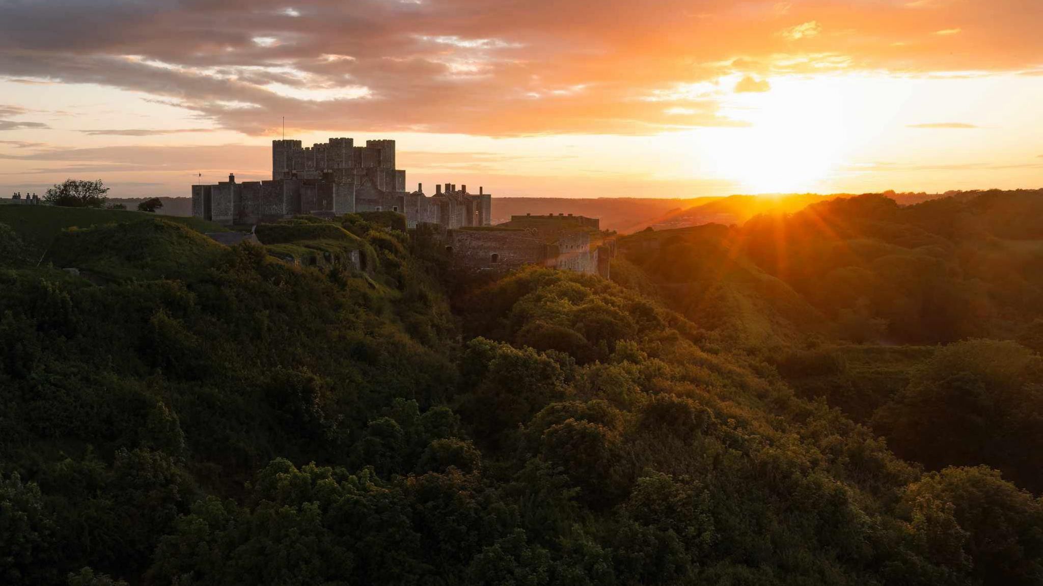 Dover Castle on a hill with the sunsetting in the back 