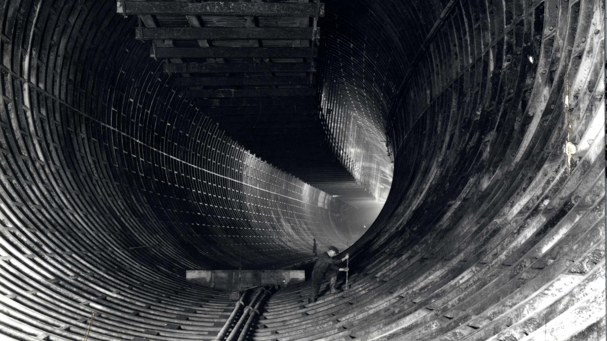 One lone worker cleans in between bricks in the tunnel