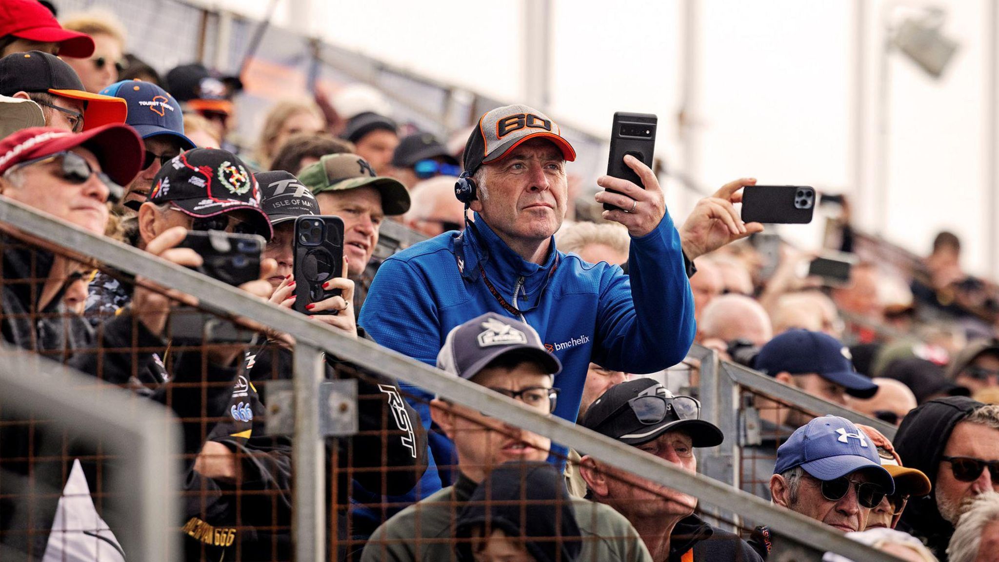 Fans on a grandstand holding up mobile phones