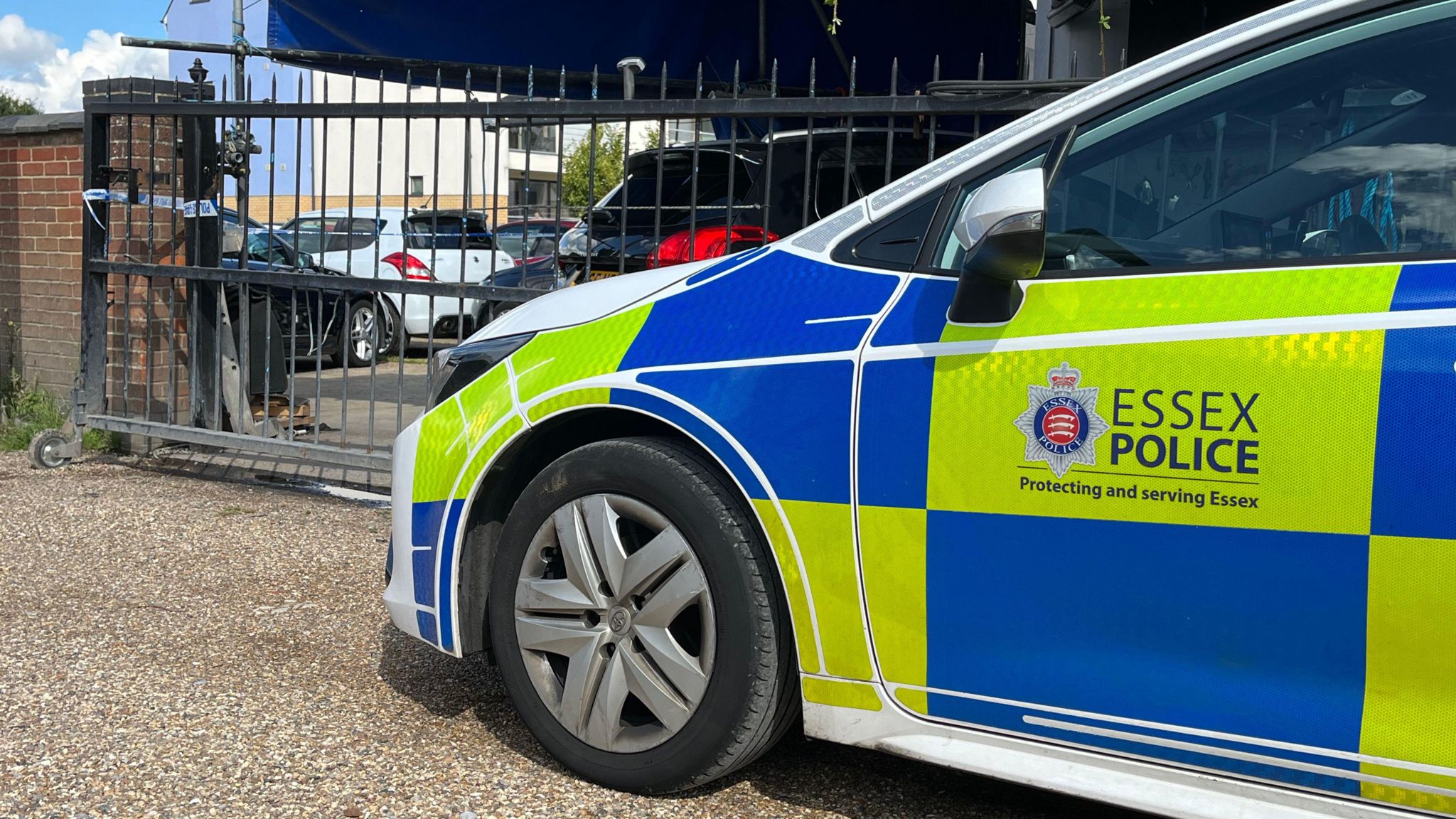 A police car parked on London Road in Marks Tey, Essex, with a spiked-metal gate in front of it