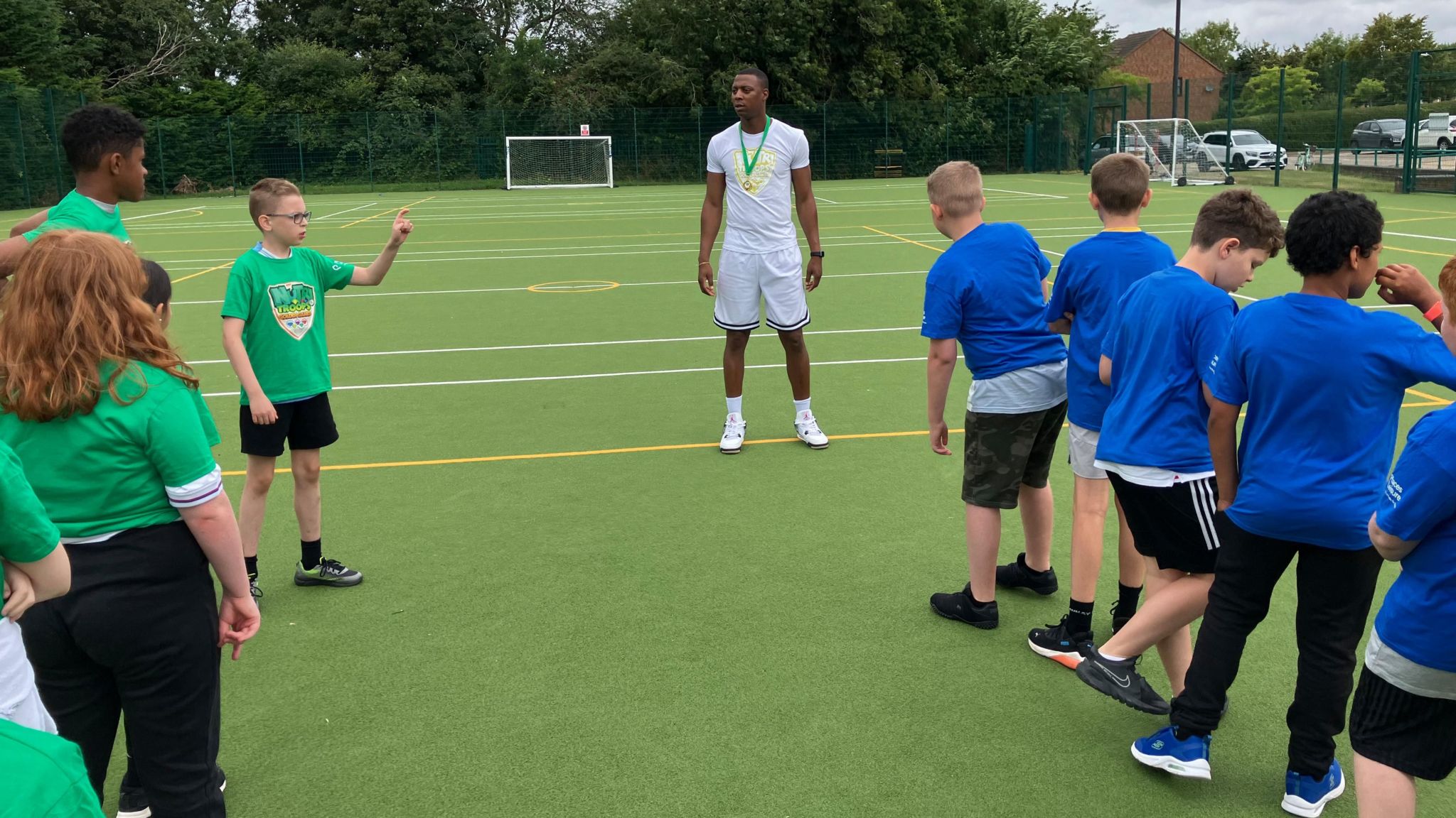 Two teams of children line up to play sports outdoors