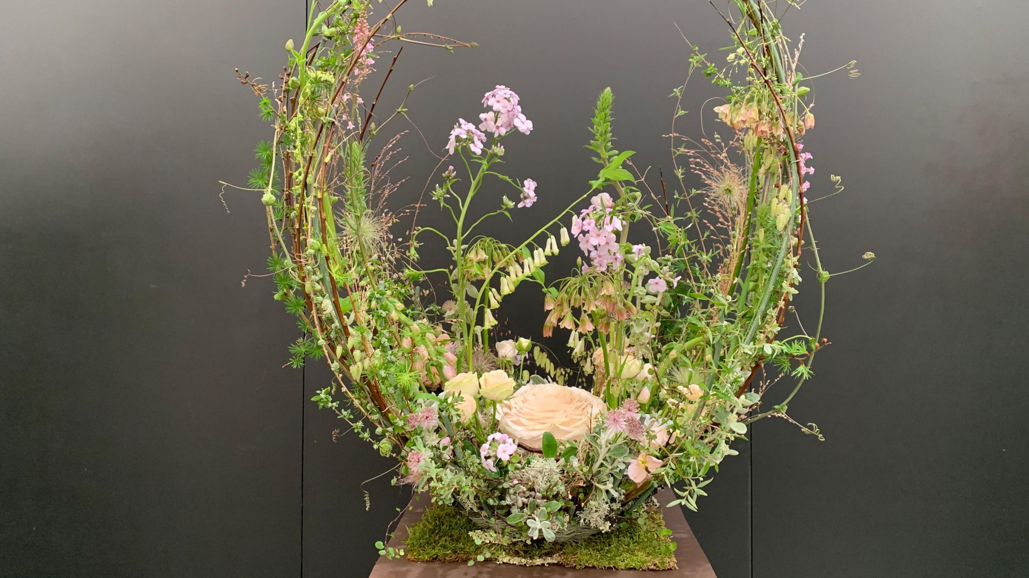 The Chelsea Flower Show exhibit, Inner Peace, which is a cocoon shaped display of grasses and pale pink, peach and lilac flowers, with a handmade rose at its centre