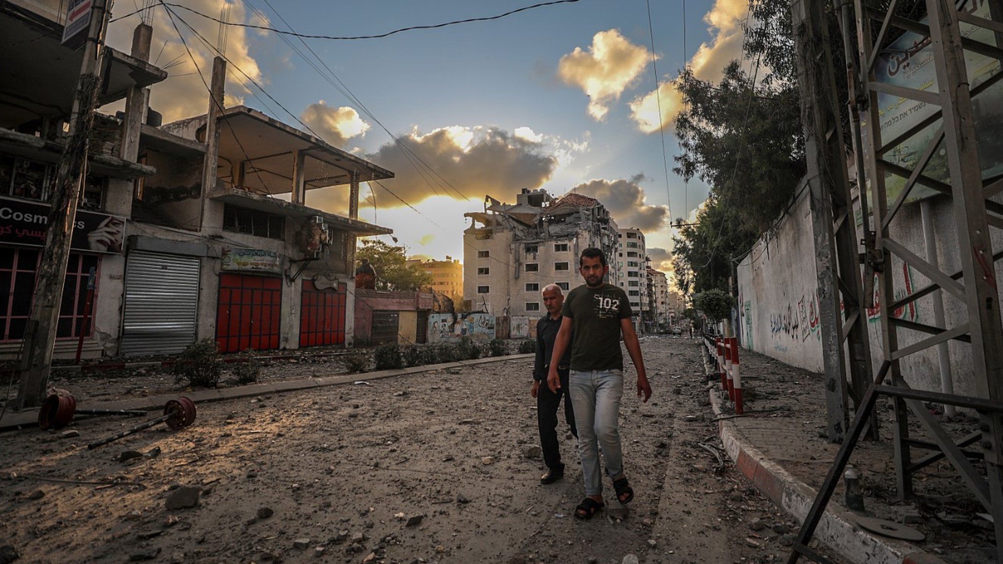 Palestinians walk past a destroyed building in Gaza City on 17 May 2021