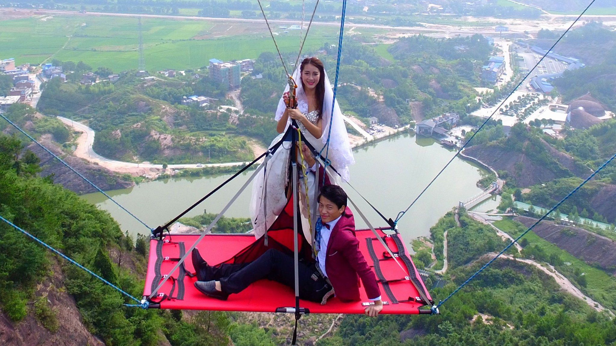 The couple suspended off Shiniuzhai glass bridge