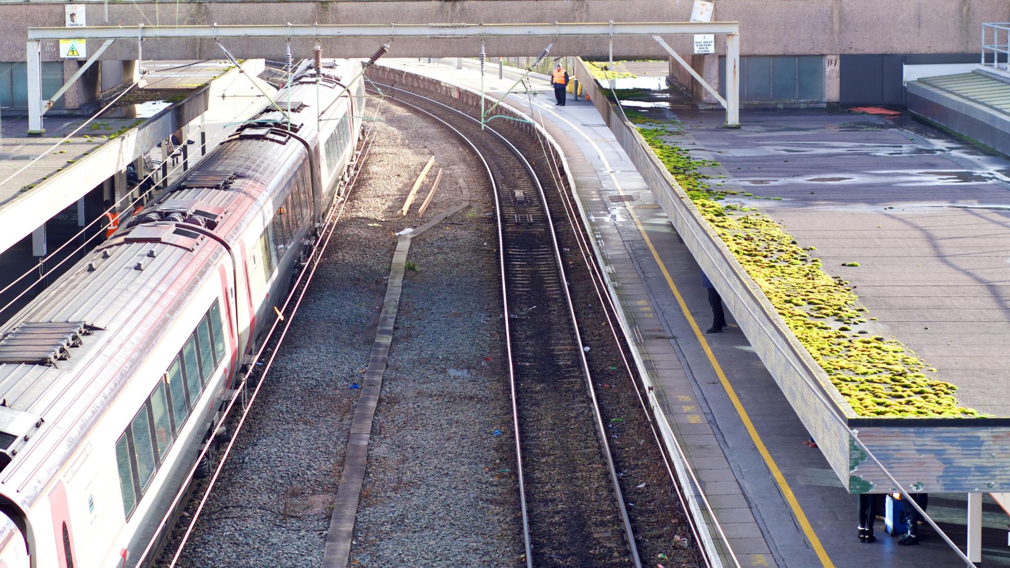 an overhead shot of Wolverhampton train station. one line is empty next to a platform, there is a train on the opposite line