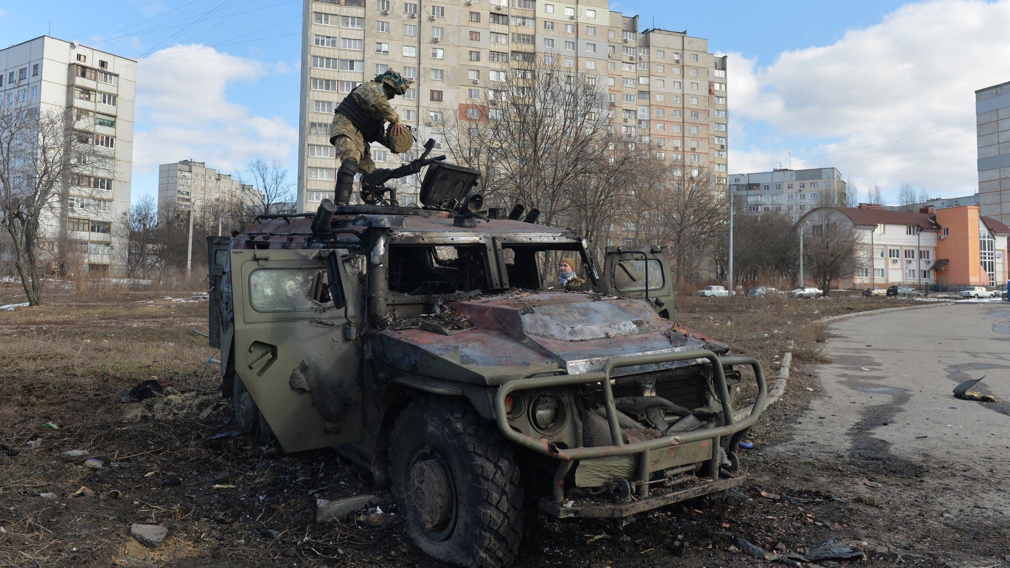 An Ukrainian Territorial Defence fighter examines a destroyed Russian infantry mobility vehicle GAZ Tigr after the fight in Kharkiv on February 27, 2022