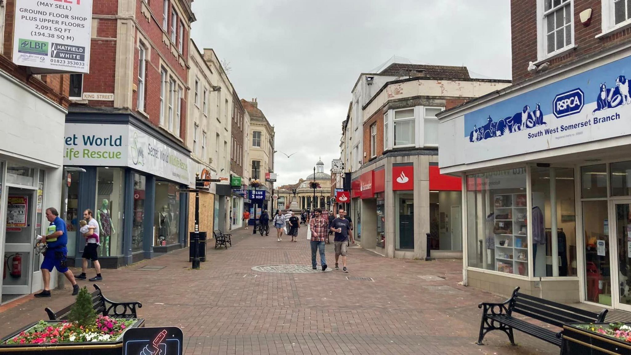 Bridgwater town centre, showing the pedestrianised high street. Shops shown include RSPCA and Secret World wildlife rescue charity shops.