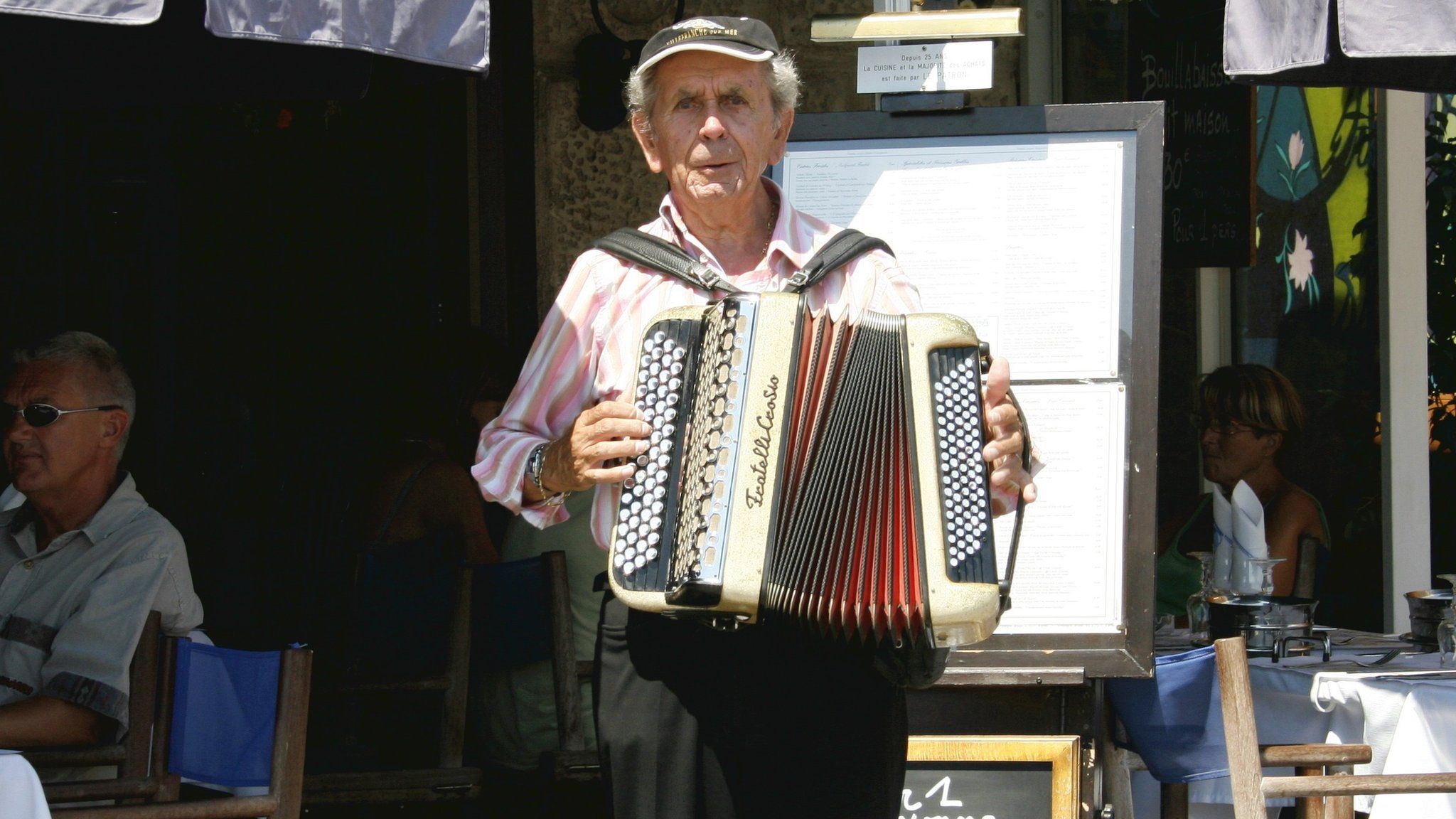 An accordion player outside a cafe in Antibes, France