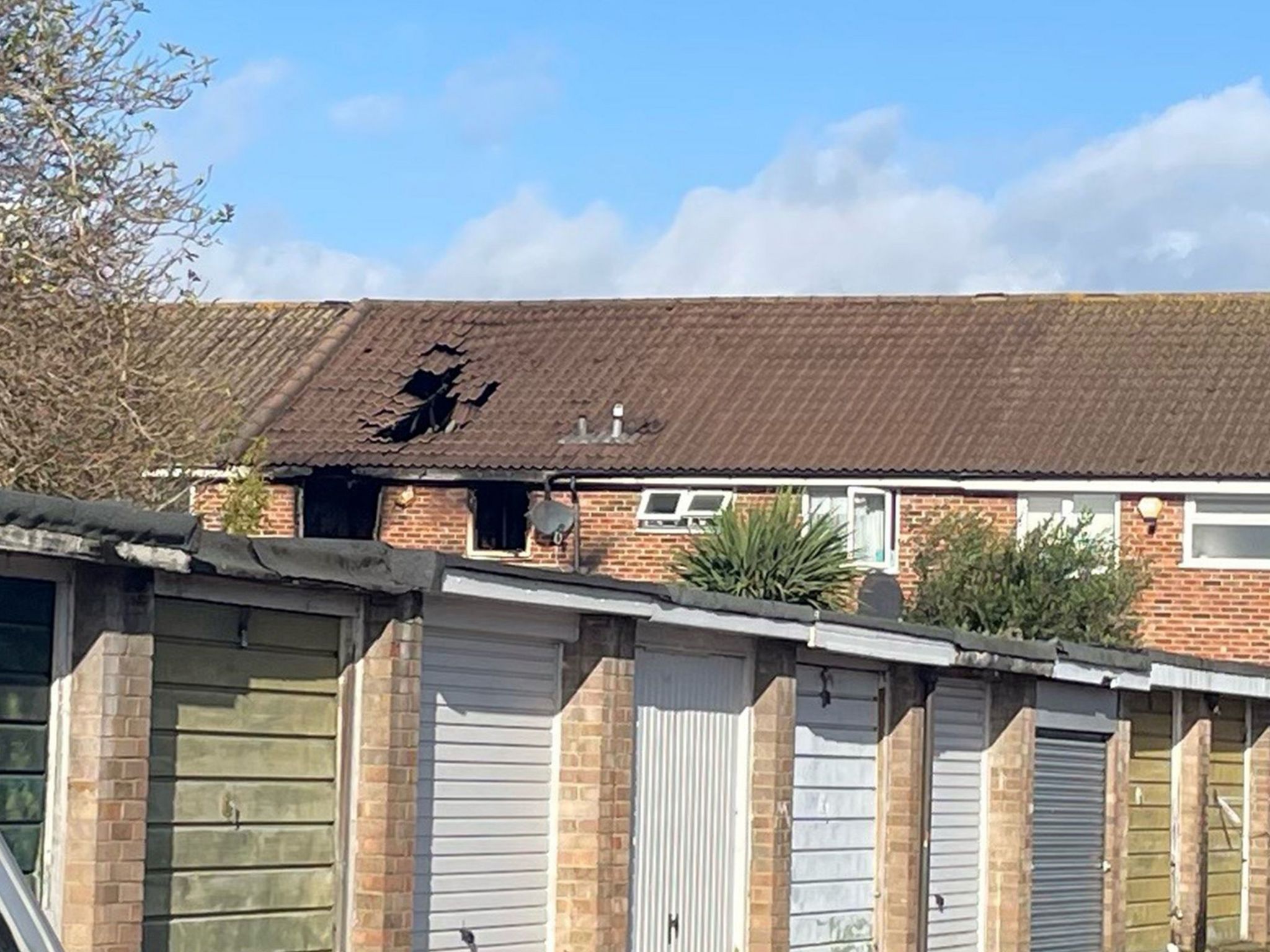 Image showing broken and burnt windows and collapsed, charred roof tiles.