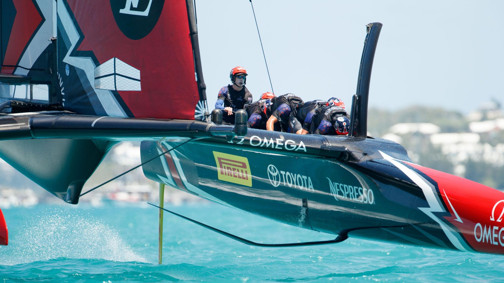 Emirates New Zealand crew at the 2017 America's Cup with four cyclors bent over and pedalling