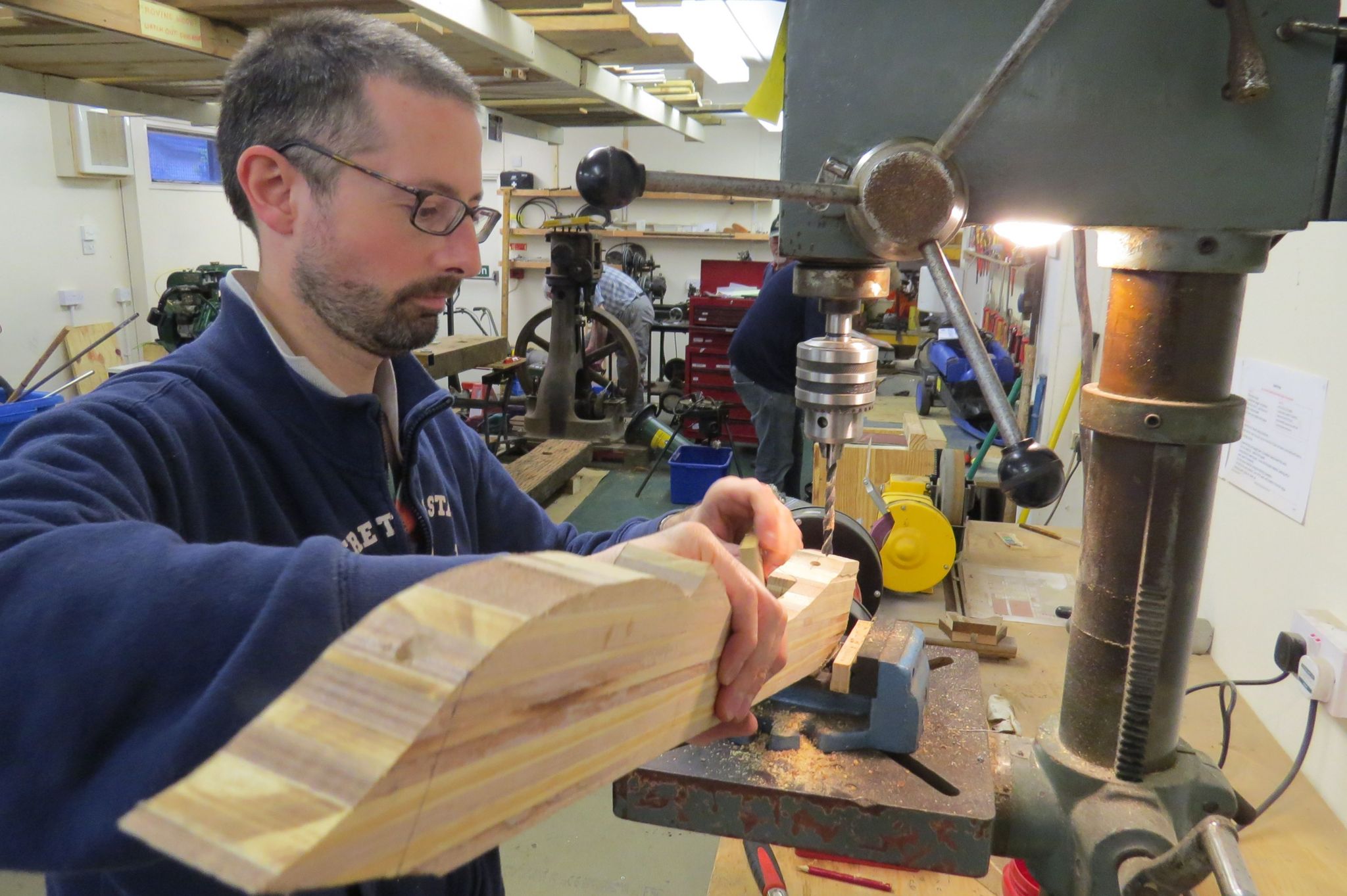 Man using a woodworking tool at a Men's Shed