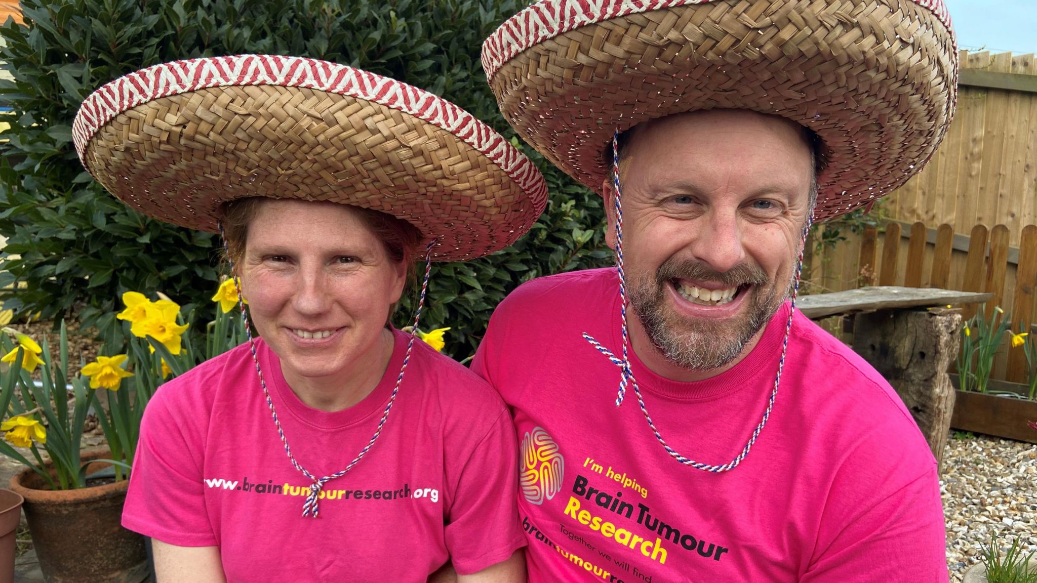 Image of Andy and his wife Suzanne wearing hats and brain tumour research charity t-shirts