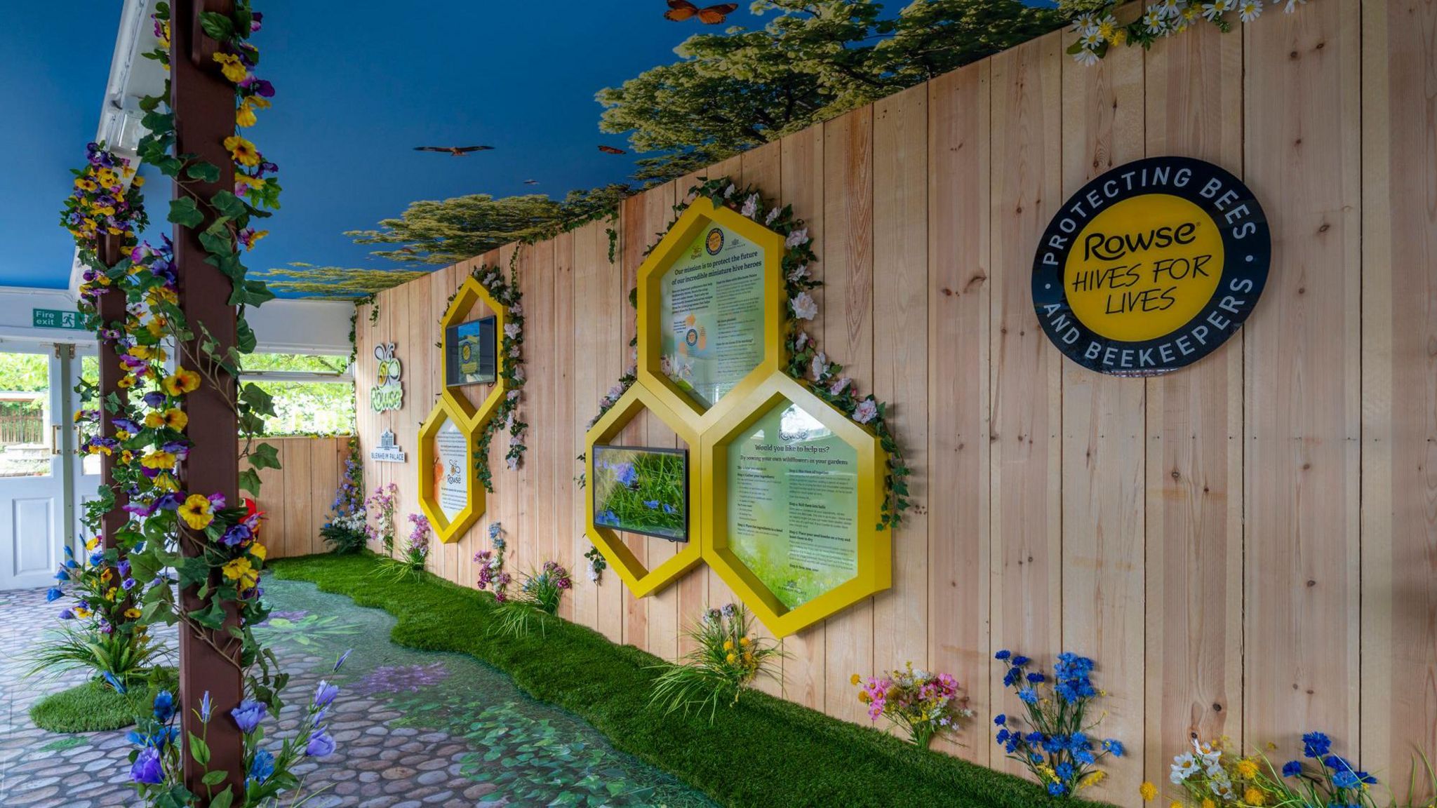 A wall display featuring information about bees, decorated with flowers