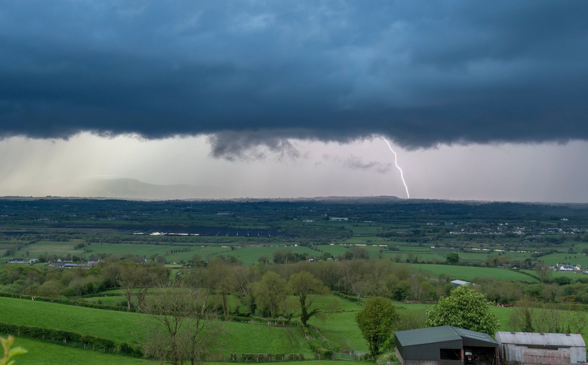 Dark thundercloud with fork of lightning hitting ground