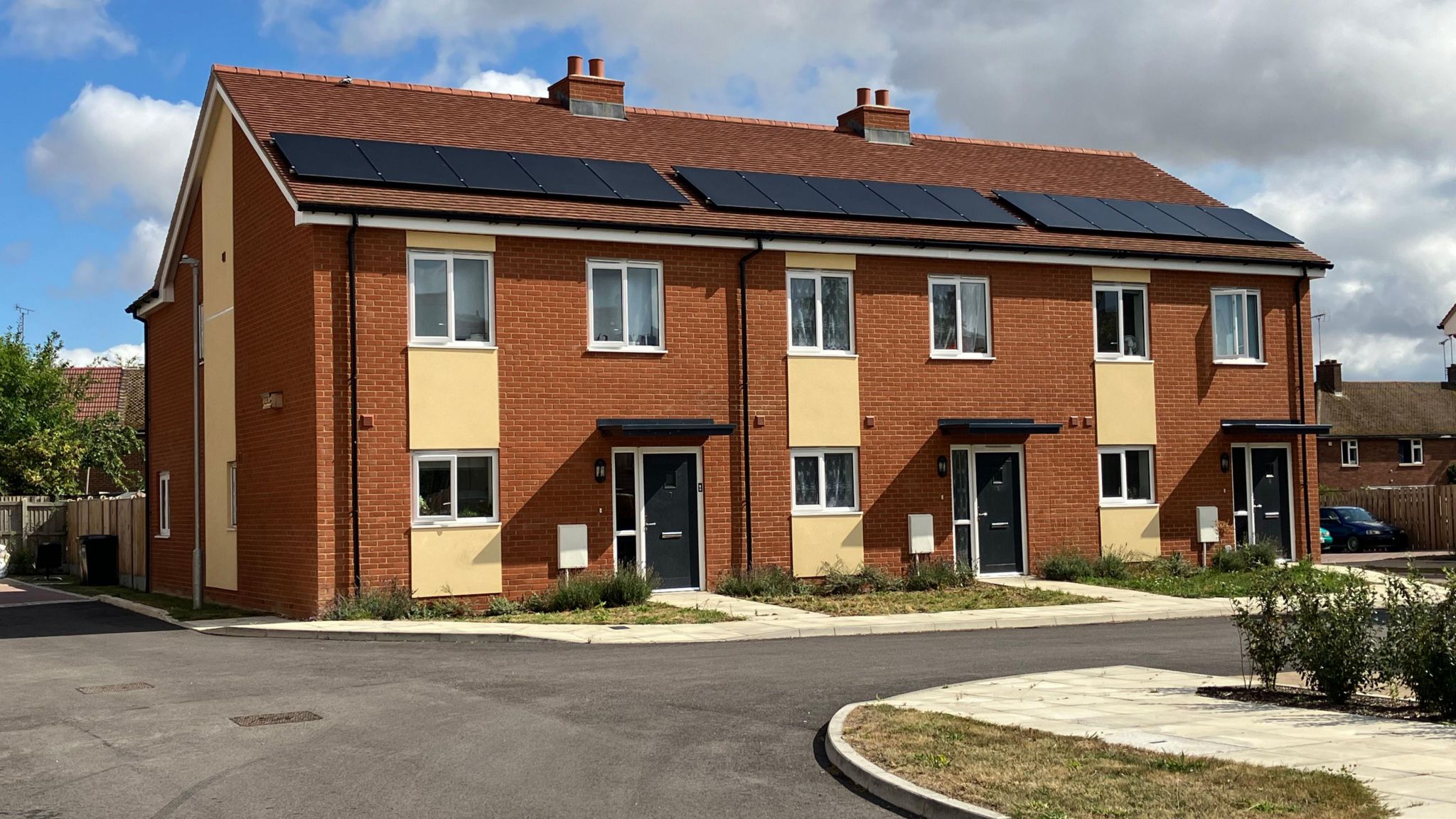 A picture showing three modern terraced houses in St Michaels Place in Chelmsford with solar panels on their roofs.