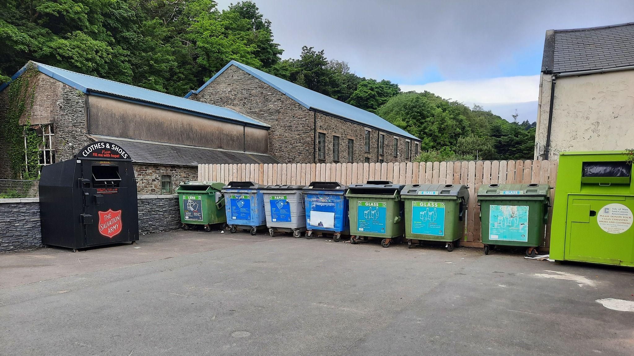 A clothes collection bin and recycling bins. 