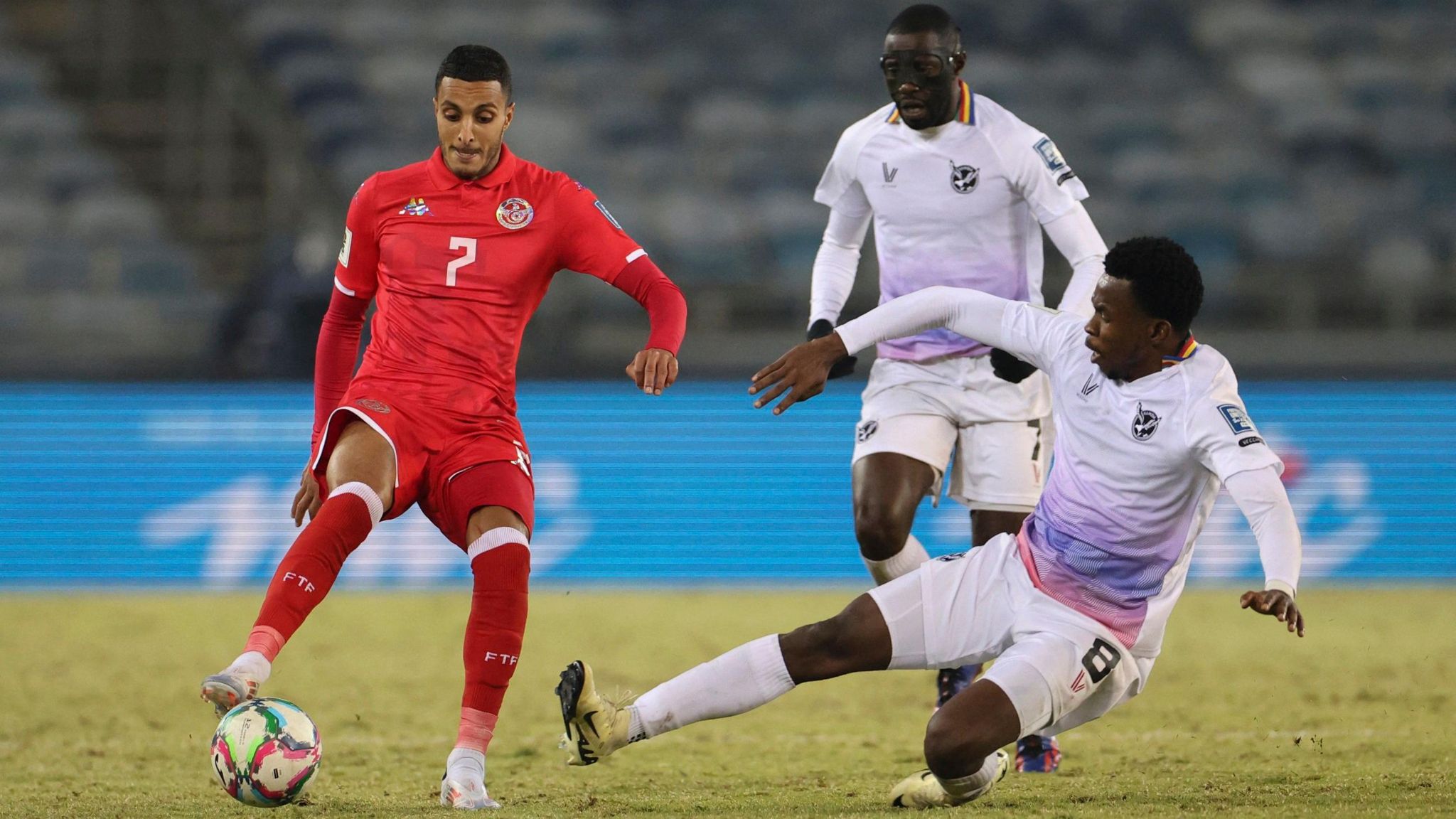Namibia's Romeo Kasume tackles Tunisia's Elias Achouri as Namibia's Deon Hotto looks on