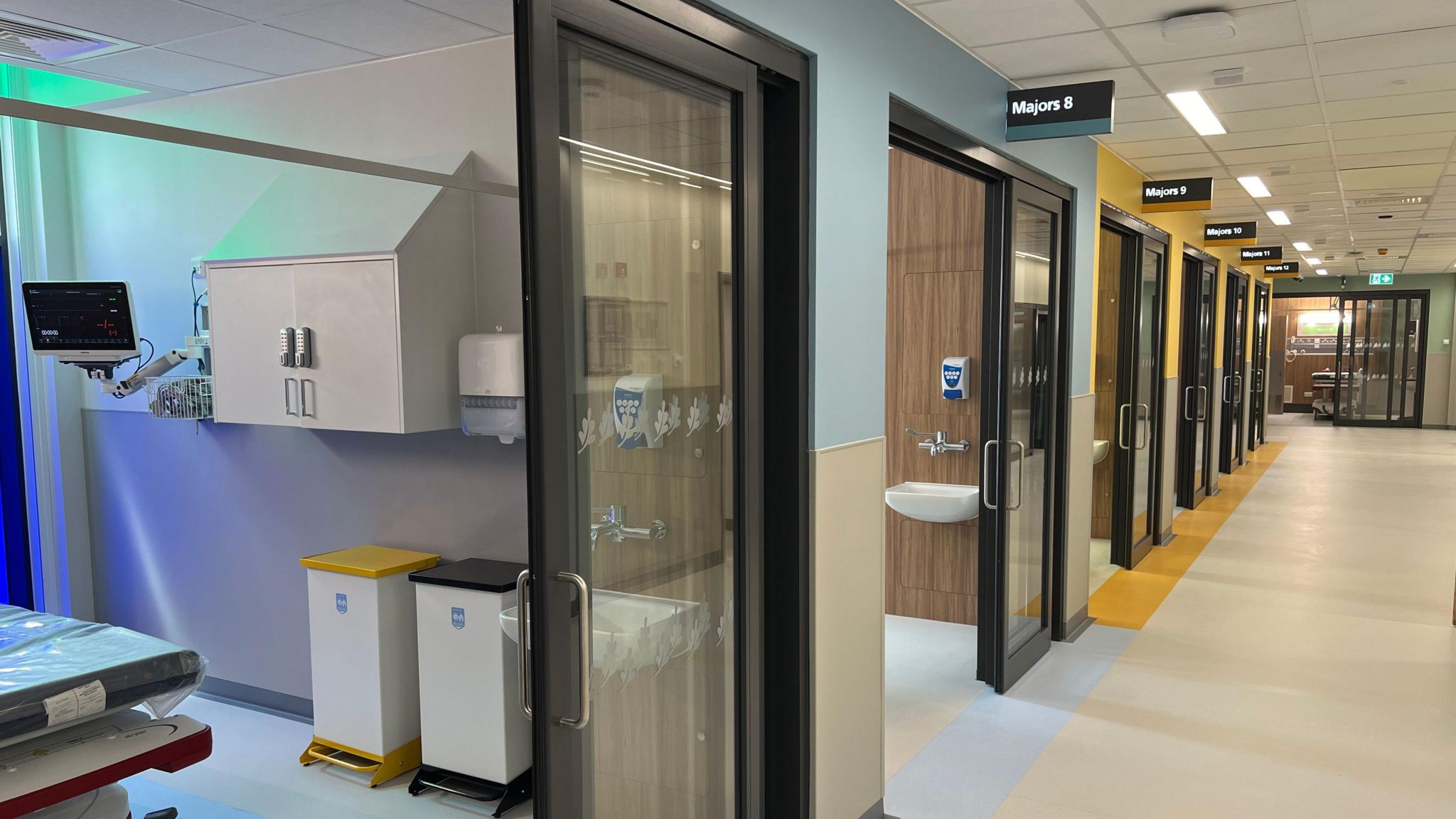 A corridor with patient treatment cubicles next to them