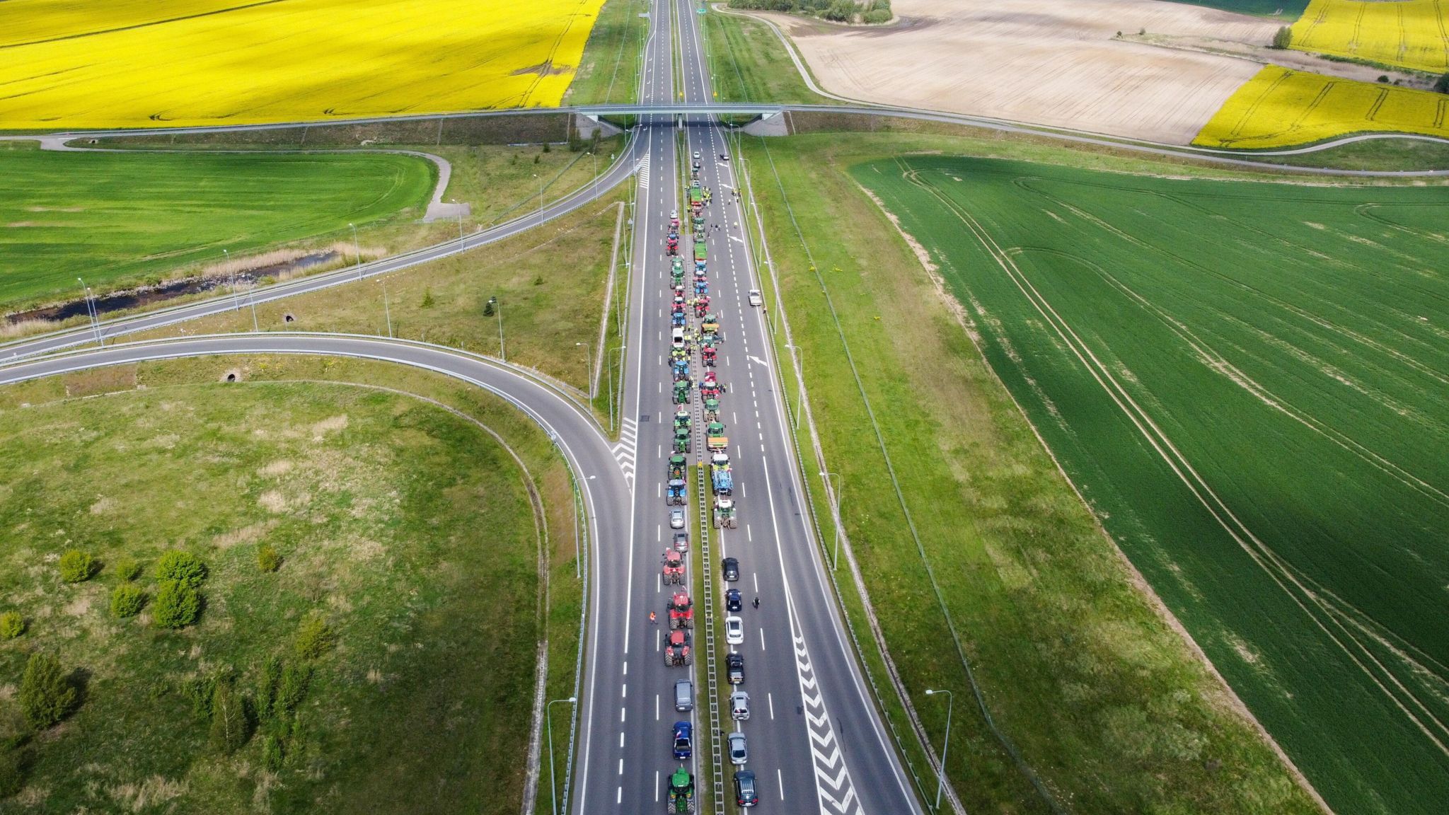 Aerial shot of a long queue of tractors on a motorway
