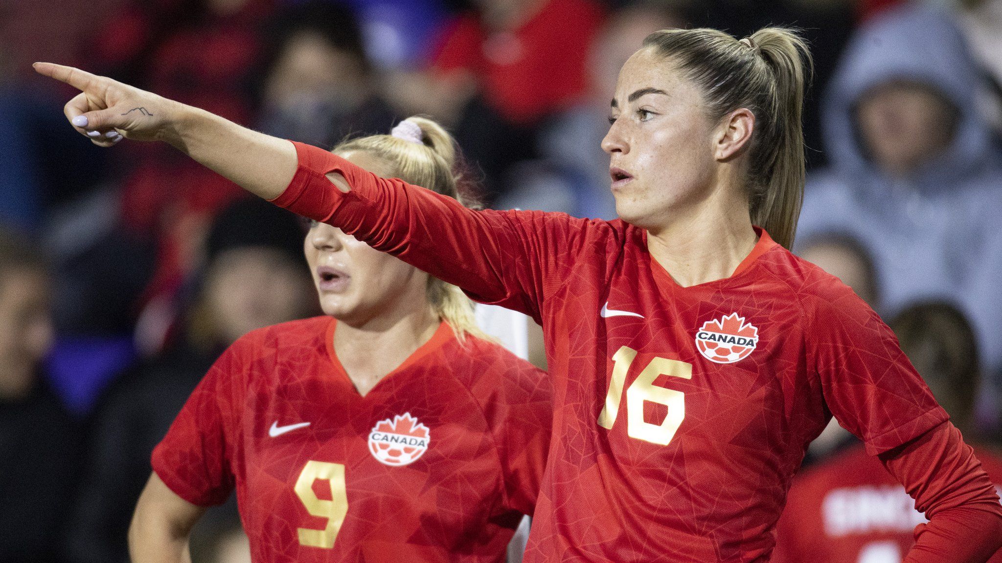 Janine Beckie points at something during a Canada match