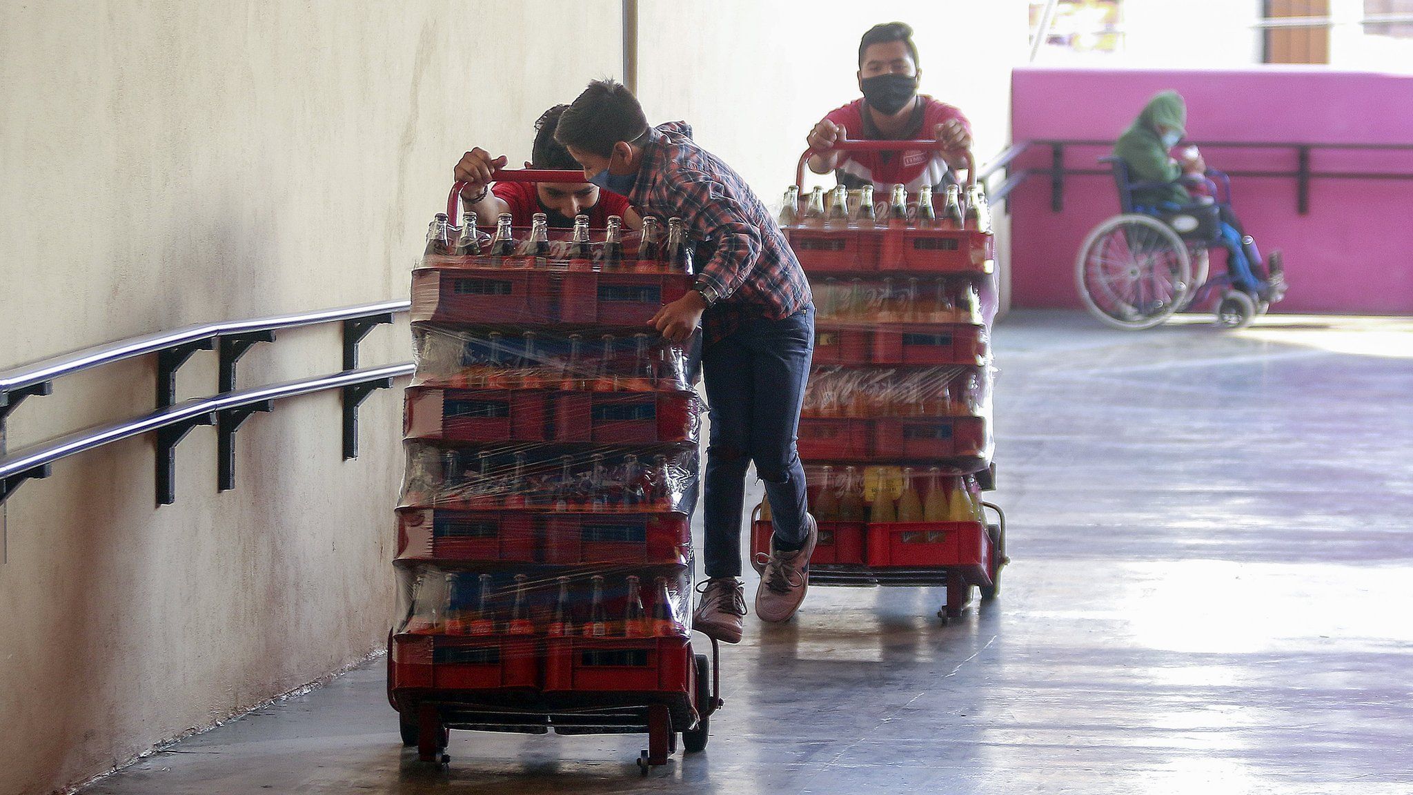 Workers carry sodas while wearing protective masks on May 9, 2020 in Queretaro , Mexico.