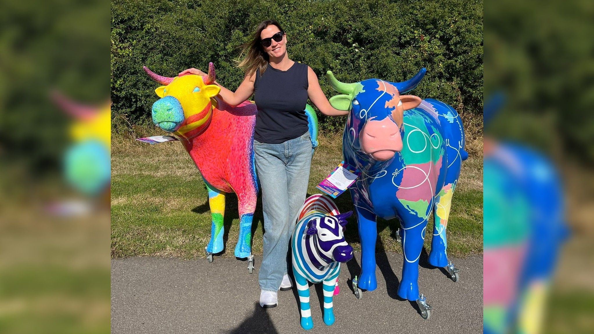 Claire Redfern with three multi-coloured sculptures stood outside