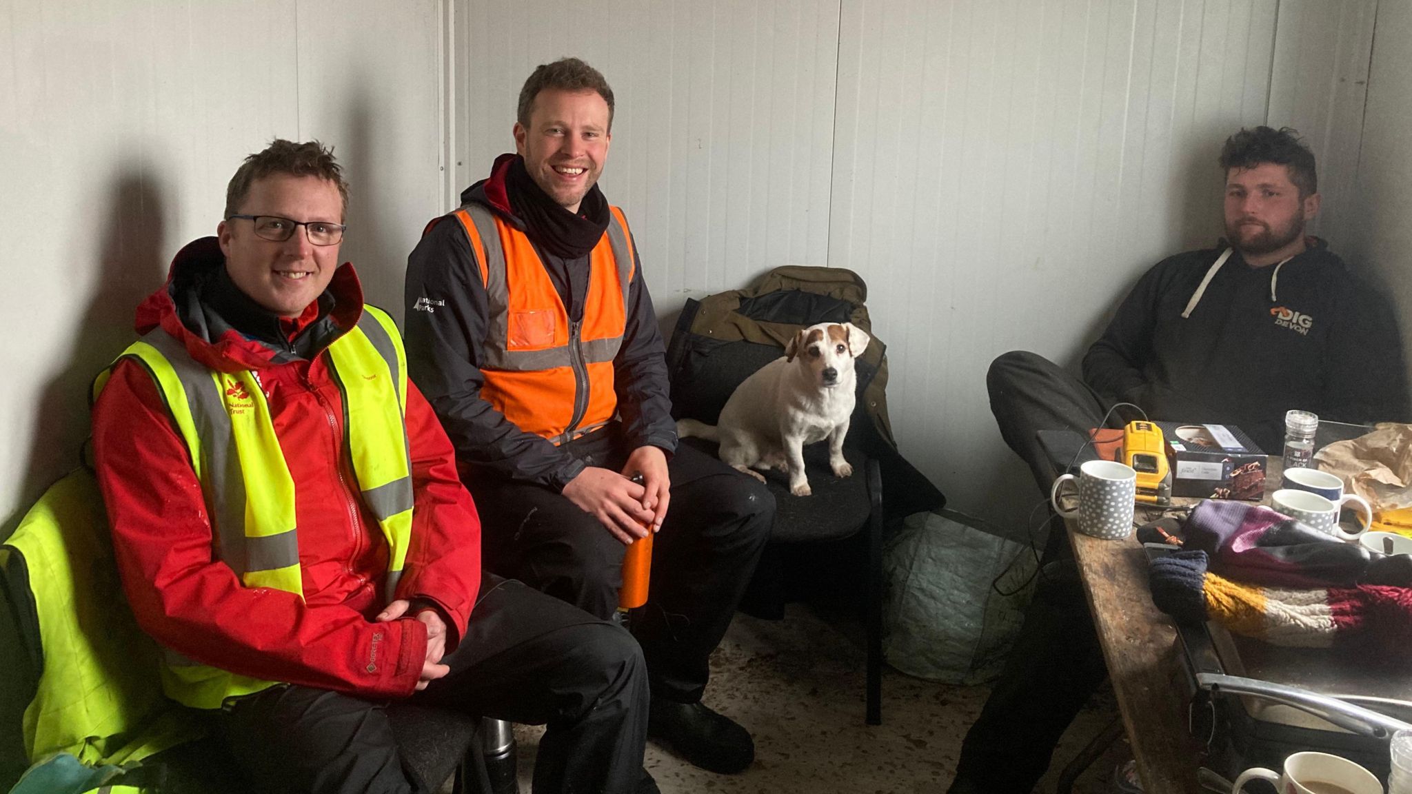 Peatland restoration workers having a break in a cabin with a dog. 