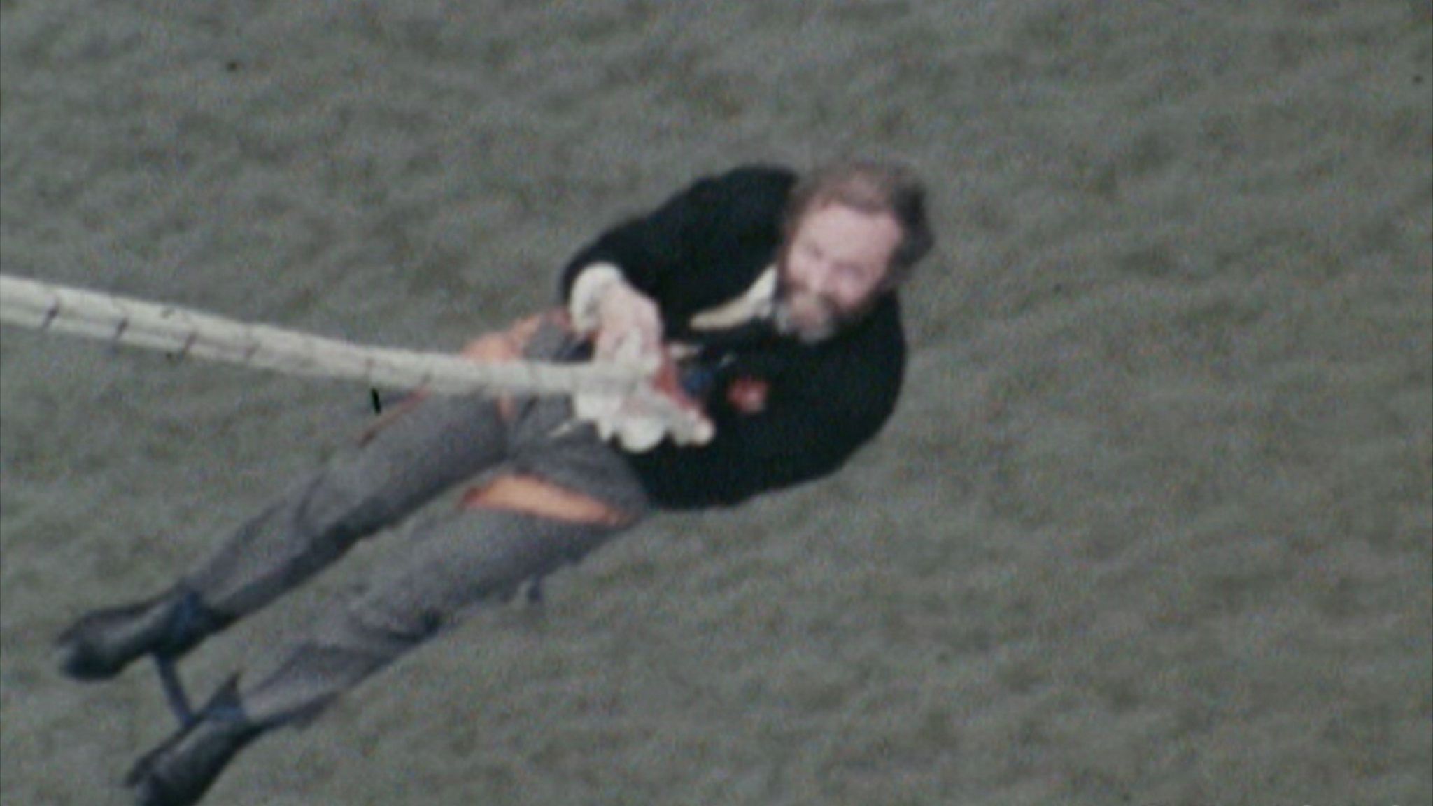 David Kirke hanging from a rope in a blurry shot