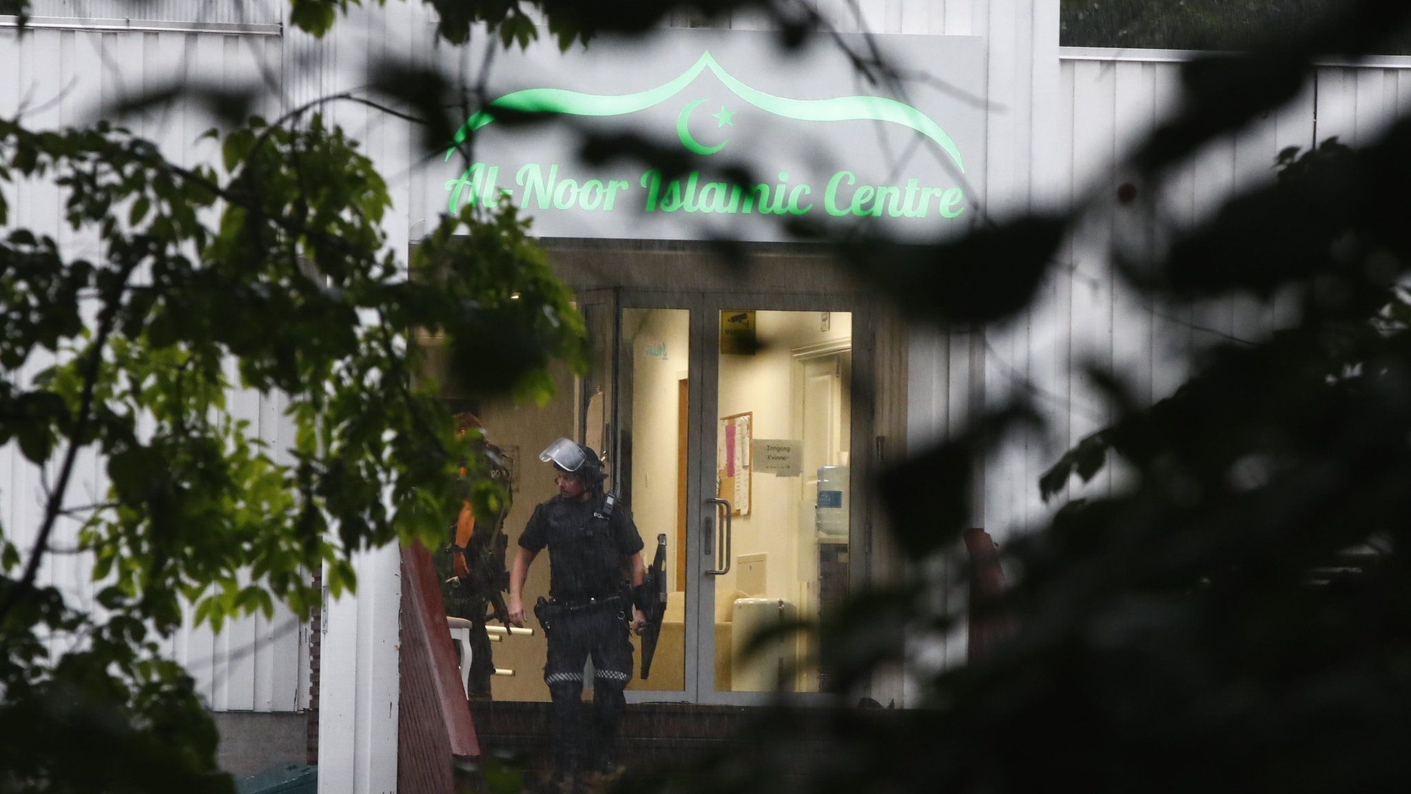 A Norwegian riot policeman stands in front of the al-Noor Islamic Centre mosque in the town of Baerum where a gunman went on a shooting spree on 10 August