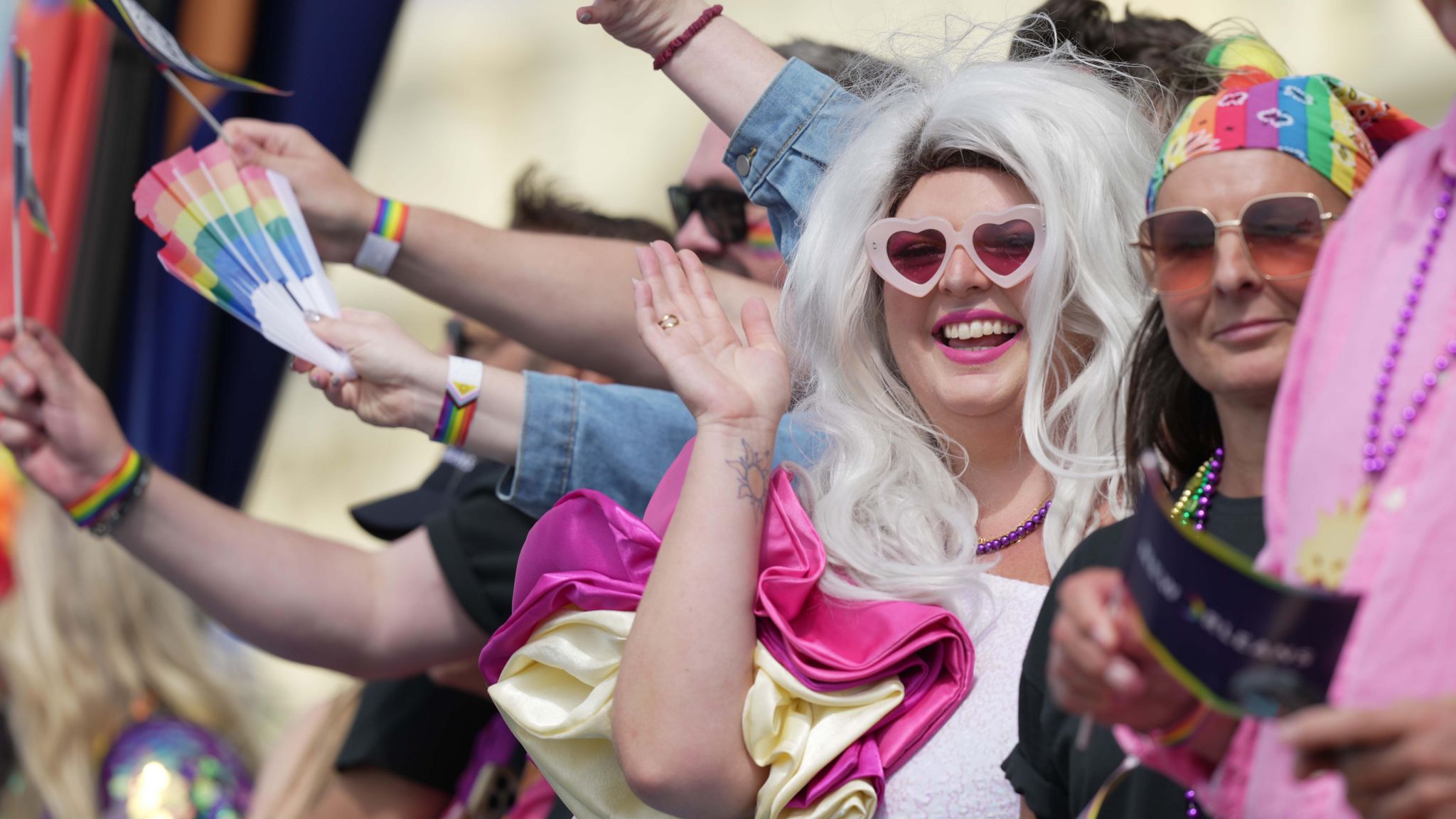 A group of people in colourful costumes waving and smiling