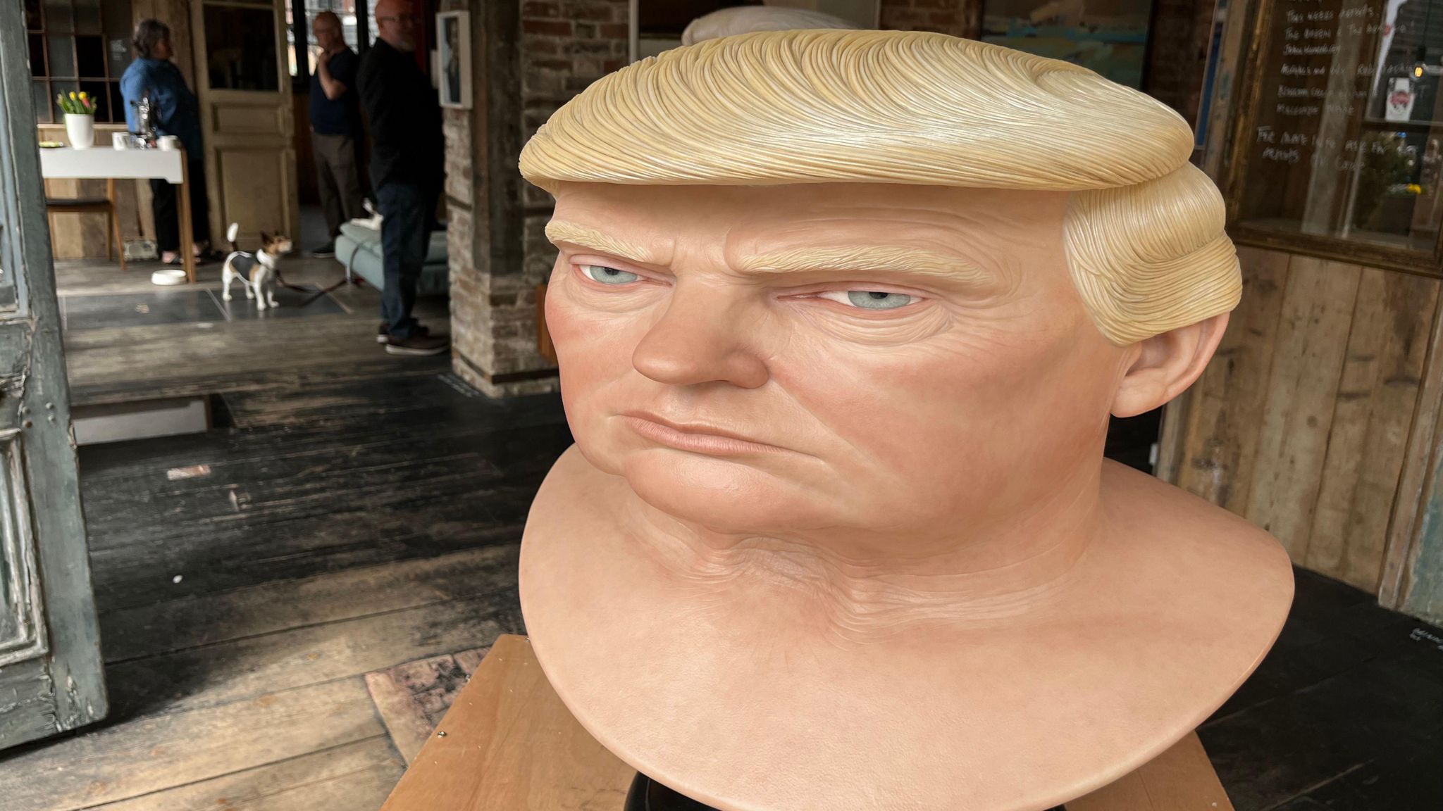 The silicone head of Donald Trump in a room with wooden floorboards