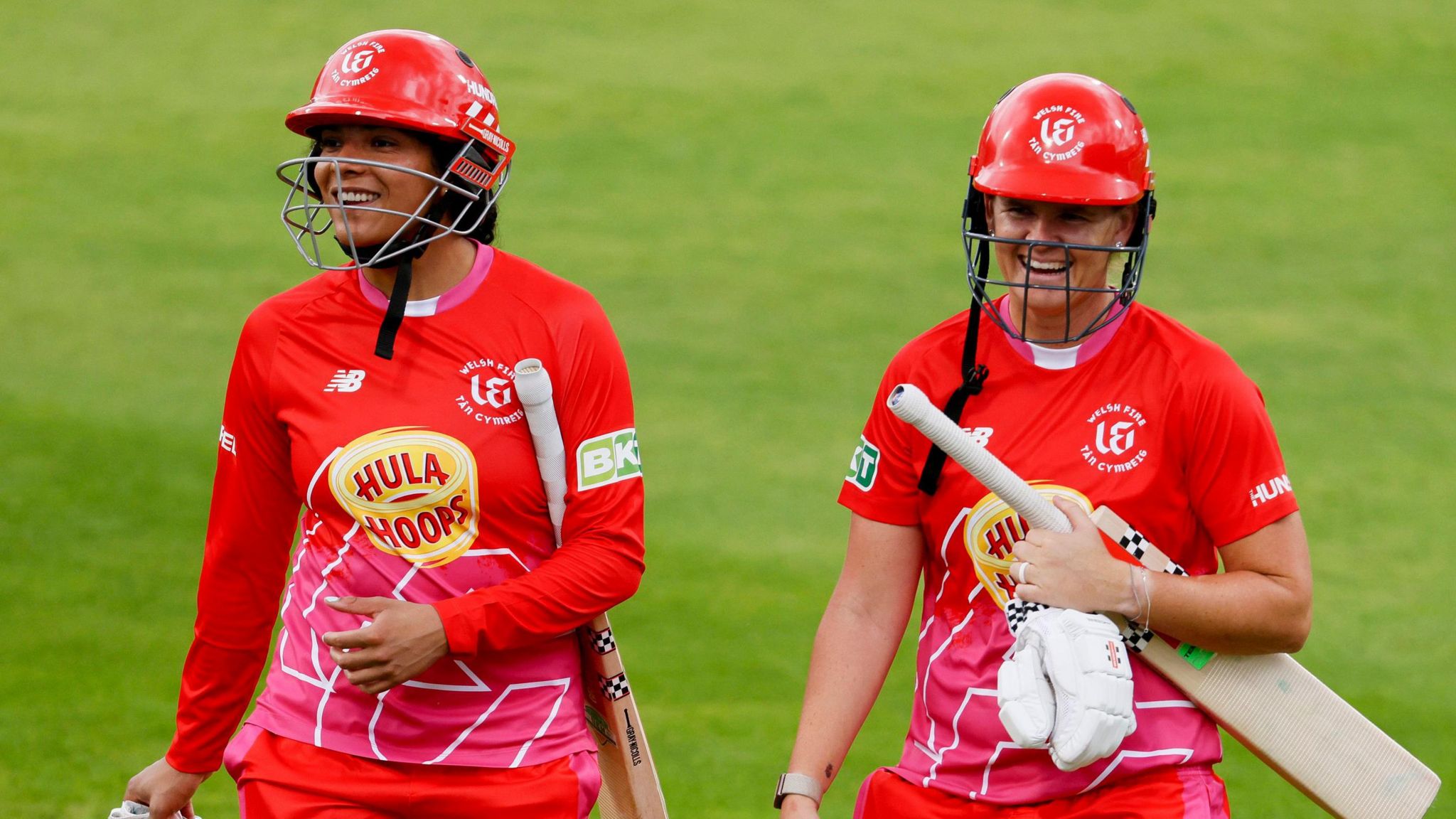 Sophia Dunkley and Jess Jonassen smile walking off the Old Trafford pitch