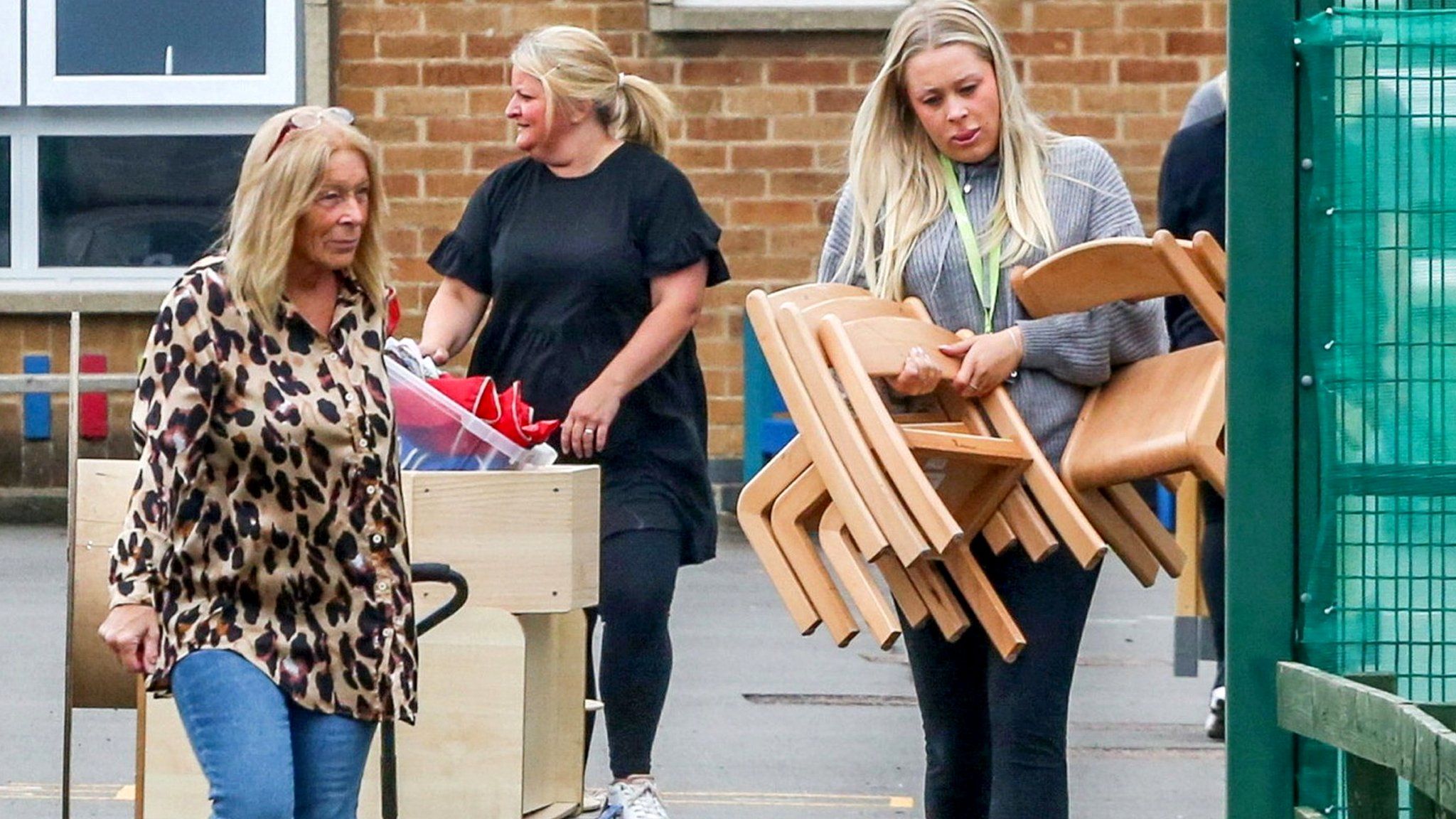 Teachers move equipment and furniture out of an affected building in Leicester
