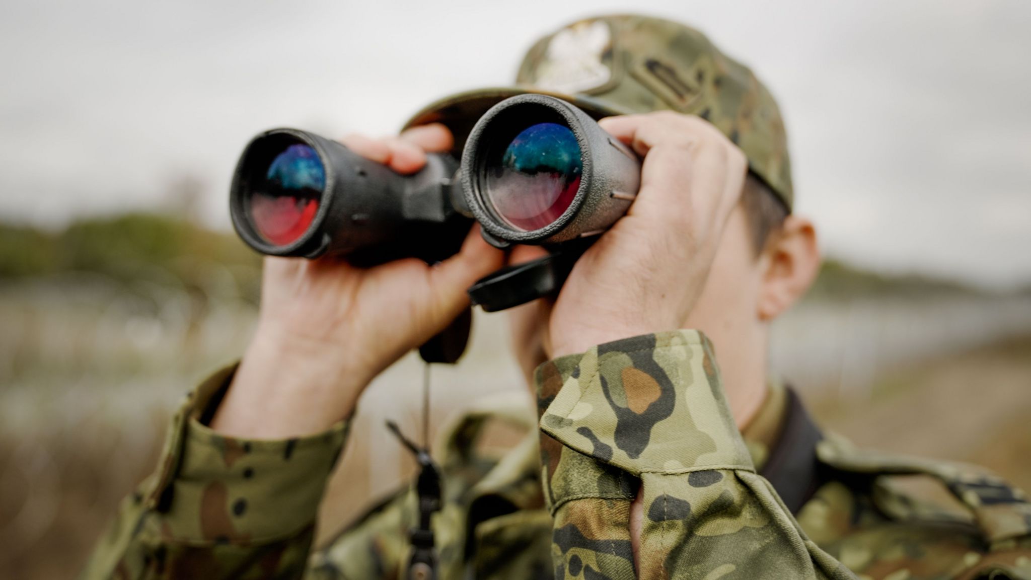 A guard with binoculars at the border with Russia
