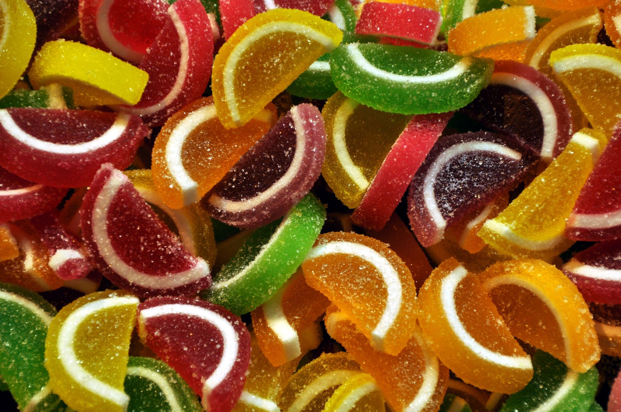 Candied sweets shaped like citrus segments of various colours on sale in a market