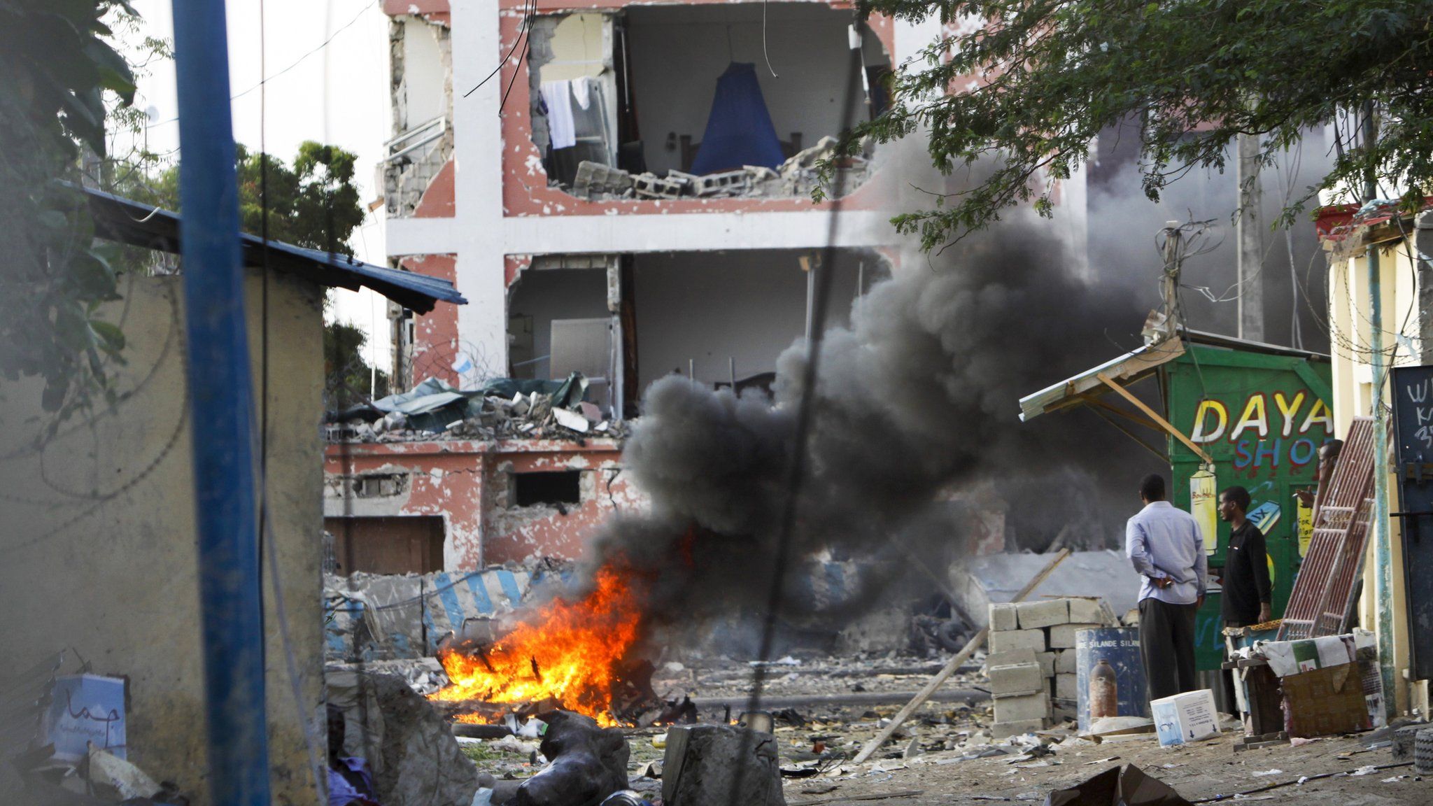 Fire burns amid the destruction outside the Sahafi Hotel in Mogadishu